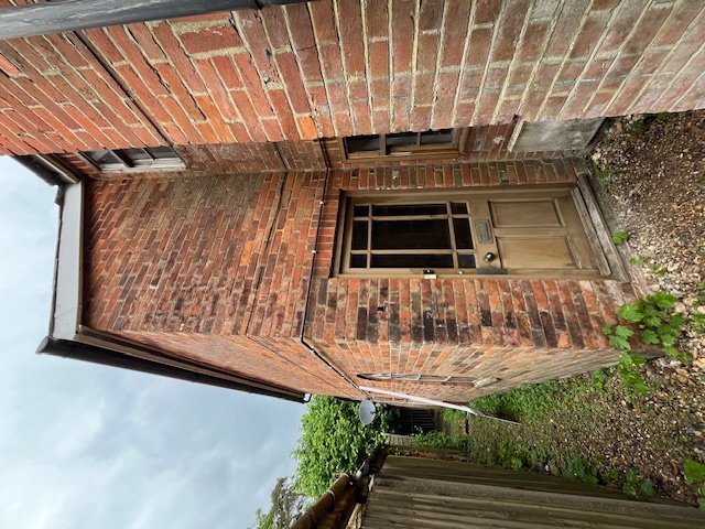 Exterior before refurb - old door, overgrown path