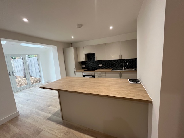 Kitchen after refurb - modern kitchen with island and hexagonal backsplash