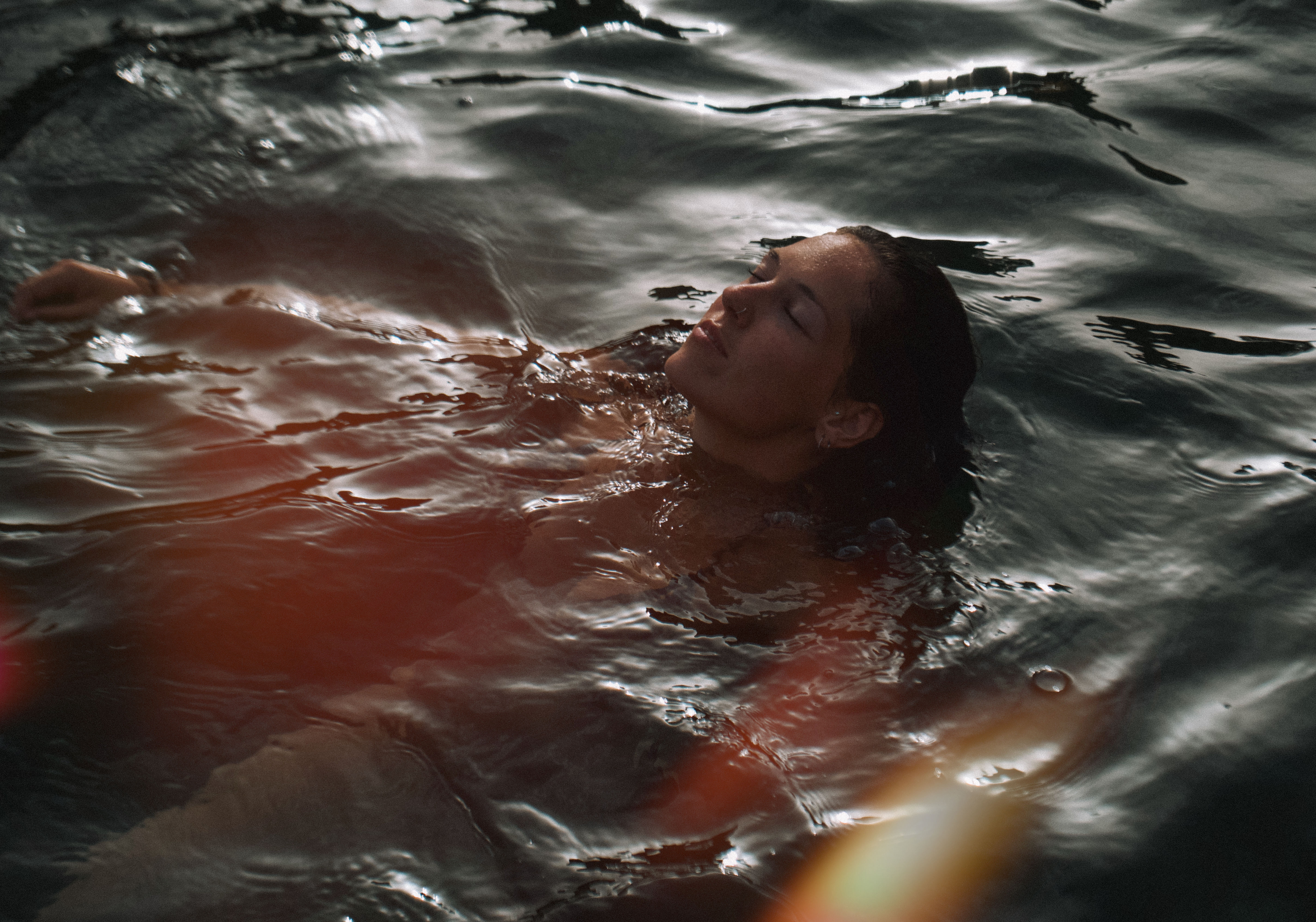 Mujer flotando en el agua en calma