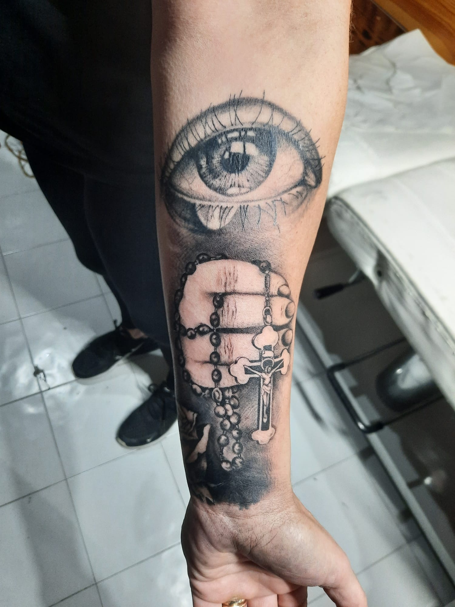 Realistic eye with rosary and crucifix tattoo by Luca Falzon