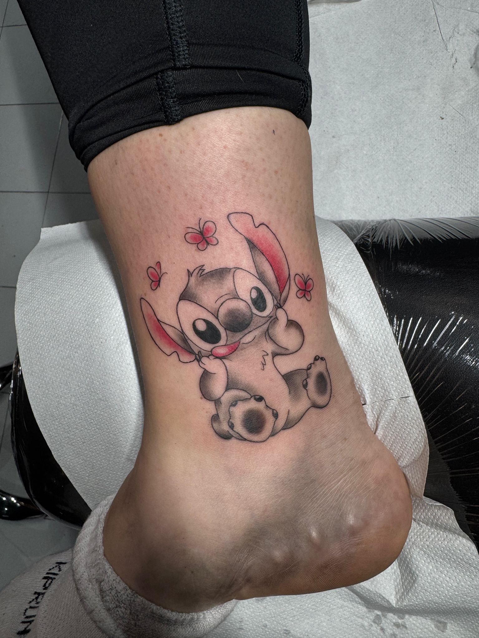 Stitch with butterflies ankle tattoo by Luca Falzon