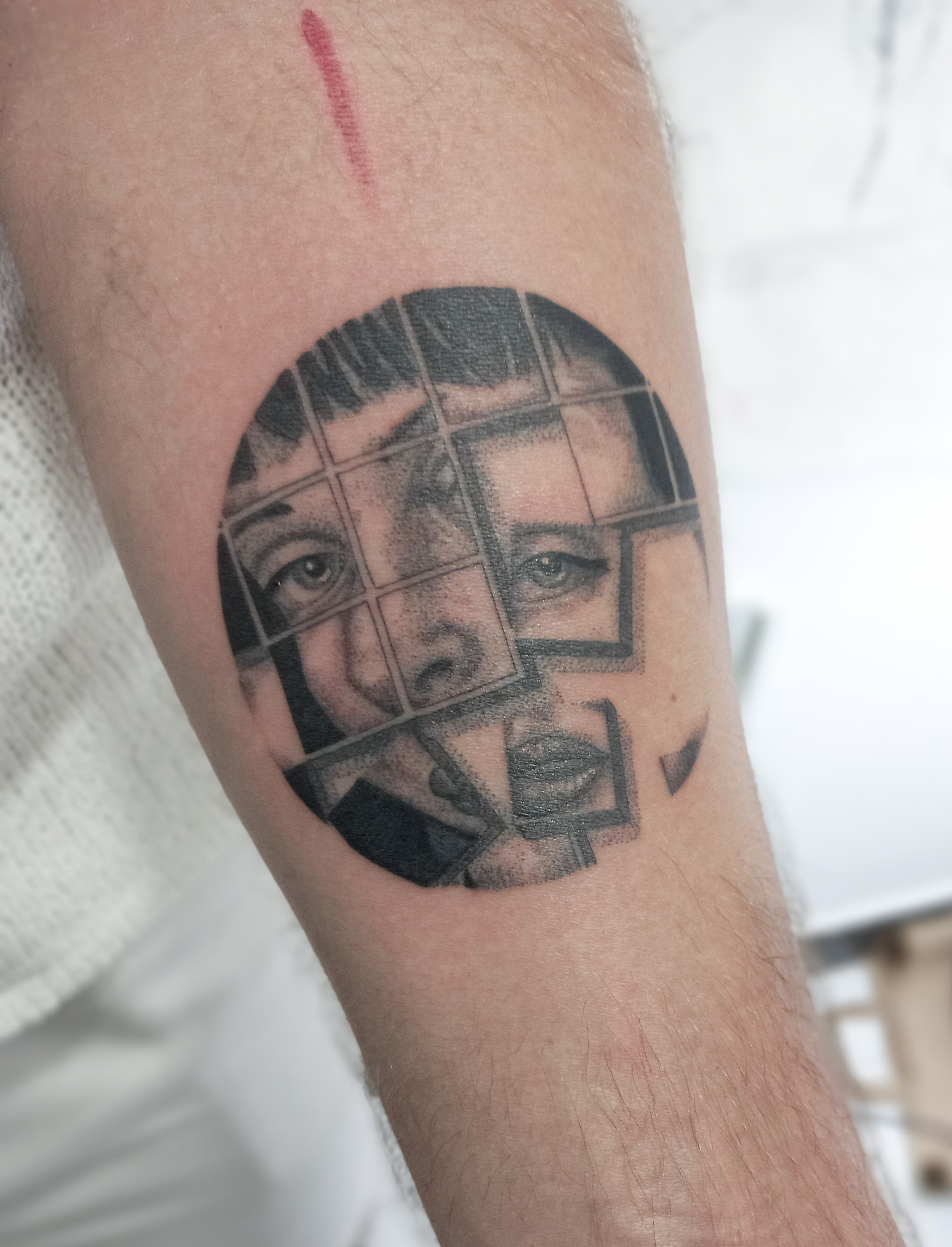 Fragmented portrait puzzle grid realism forearm tattoo by Tori Talio
