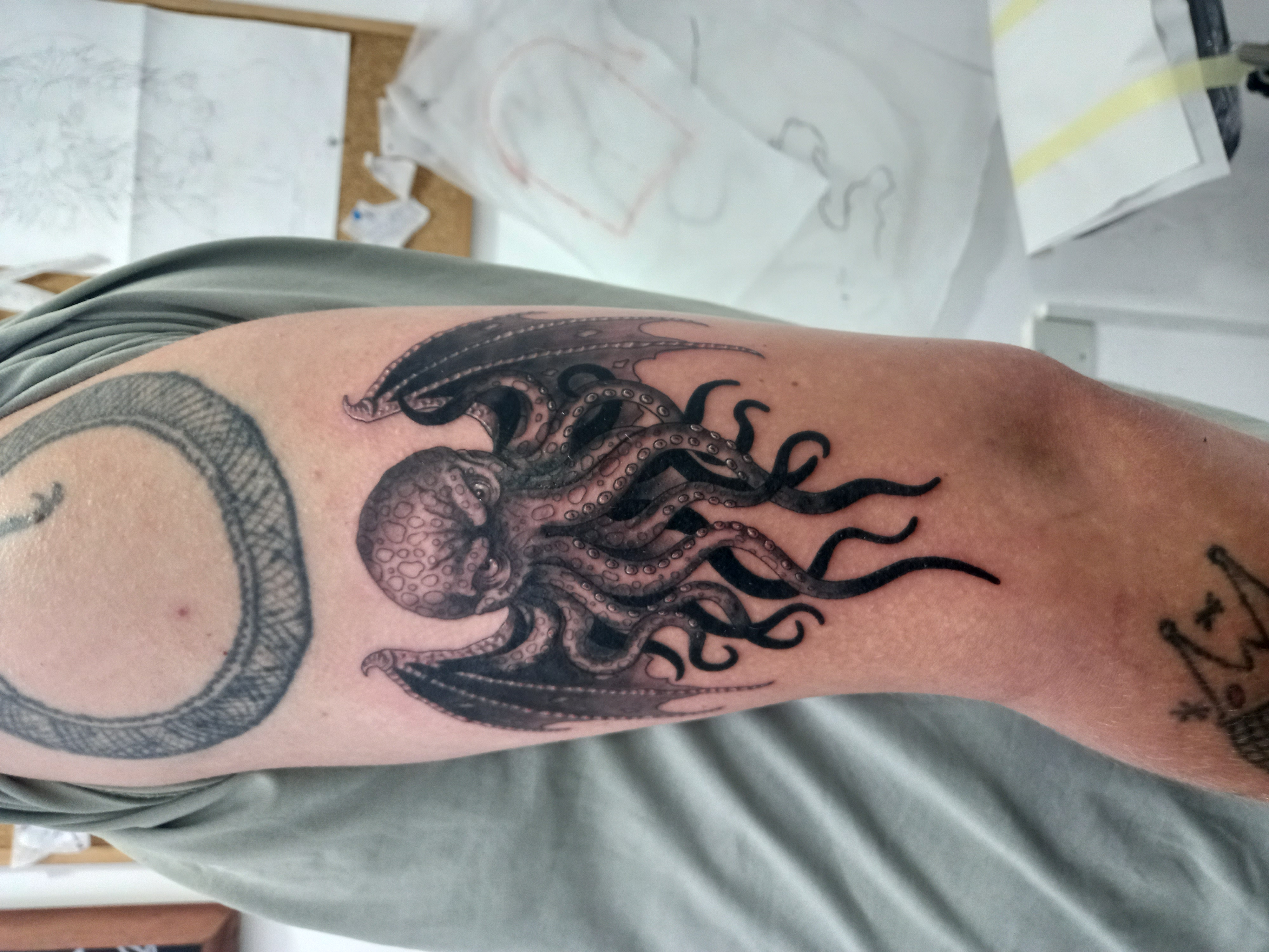 Cthulhu with ouroboros upper arm tattoo by Tori Talio