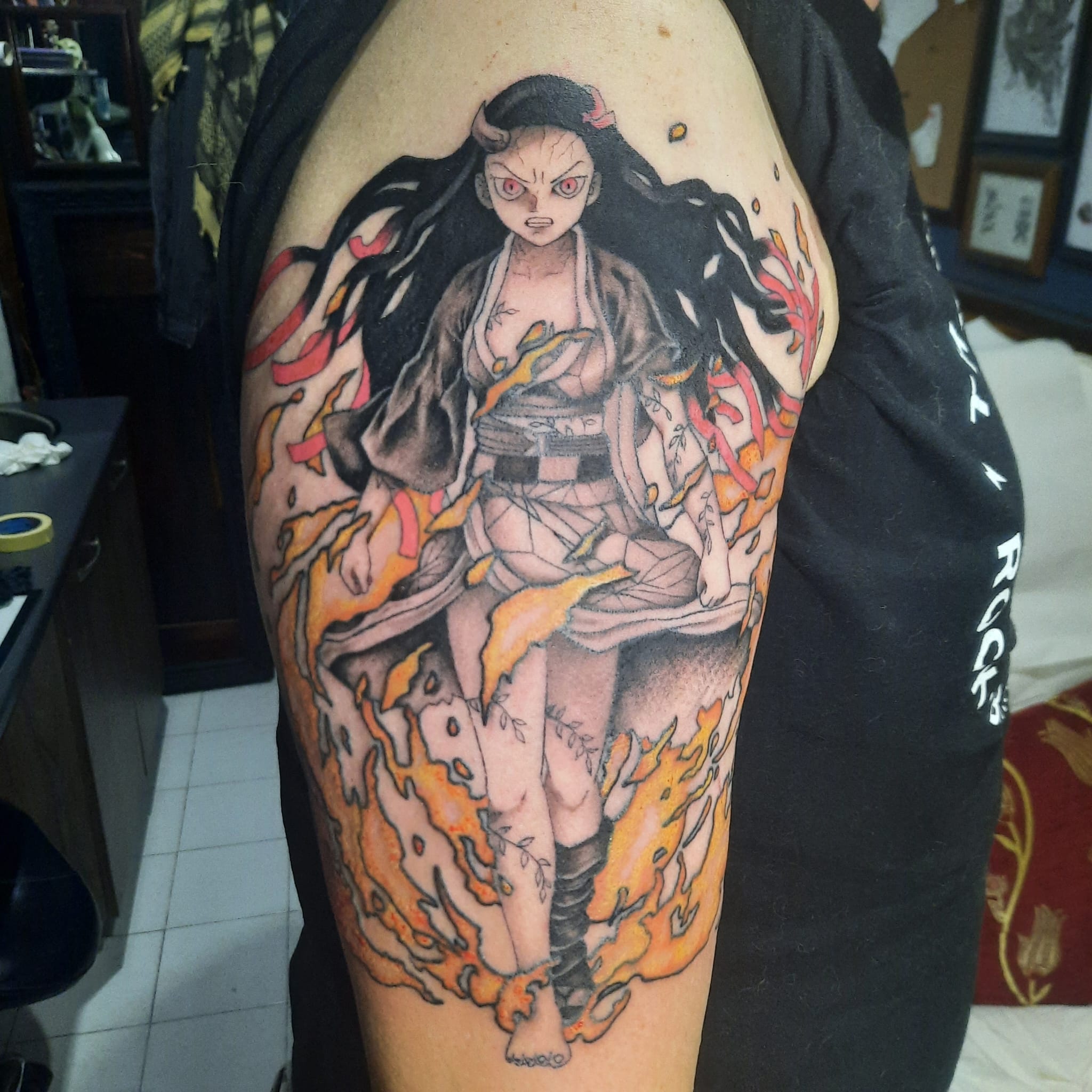 Demon Slayer Nezuko with flames upper arm tattoo by Luca Falzon