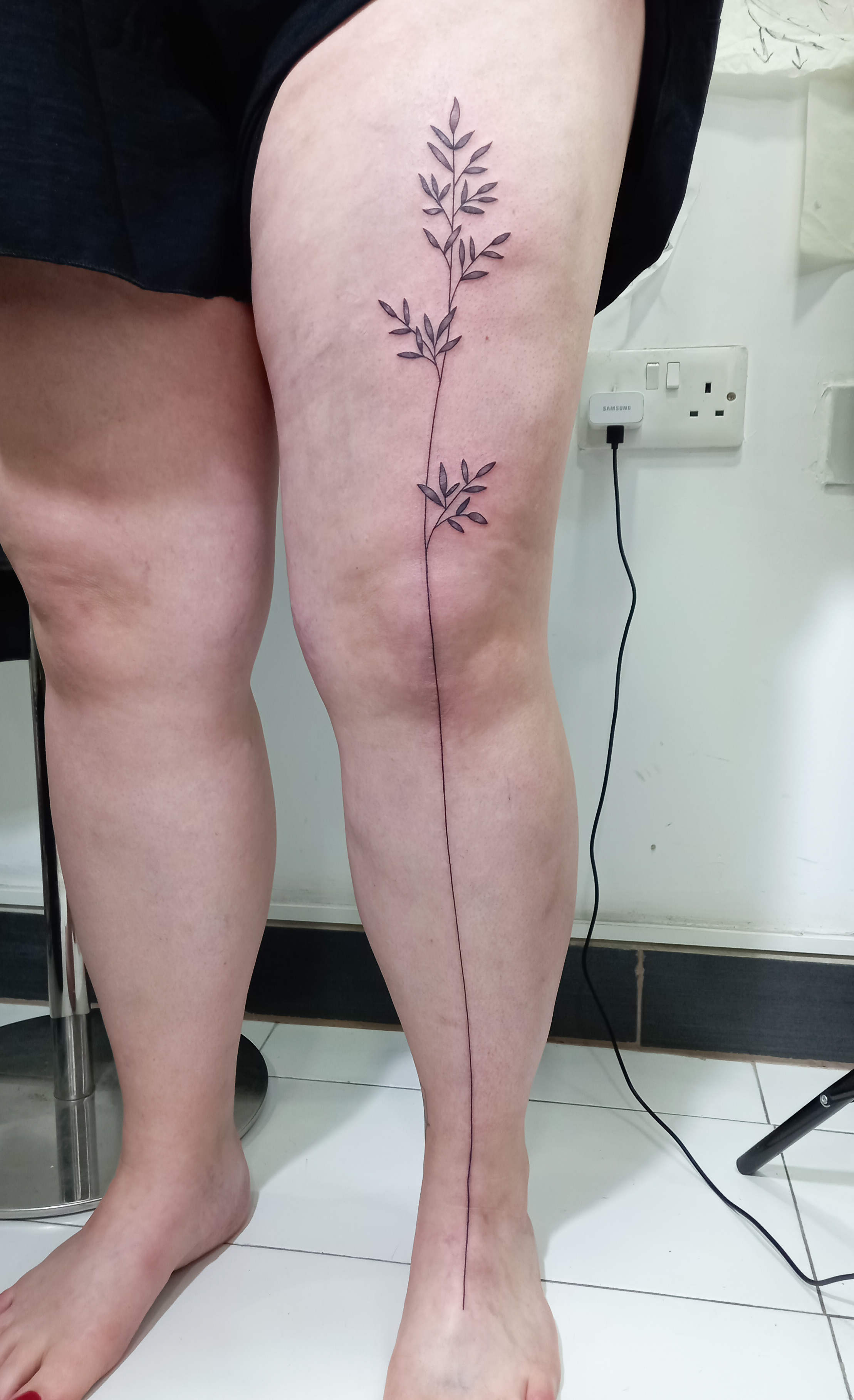Minimal leaf branch full leg line tattoo by Tori Talio