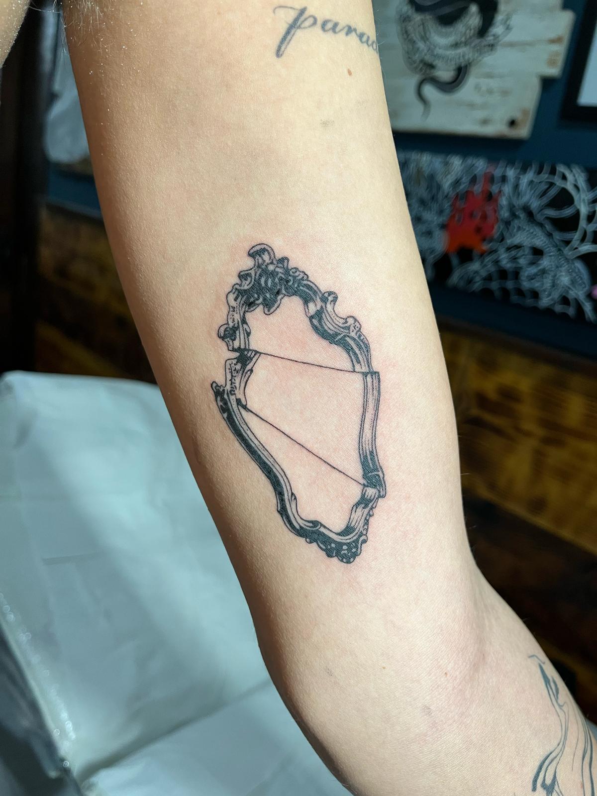 Ornate mirror frame forearm tattoo by Luca Falzon