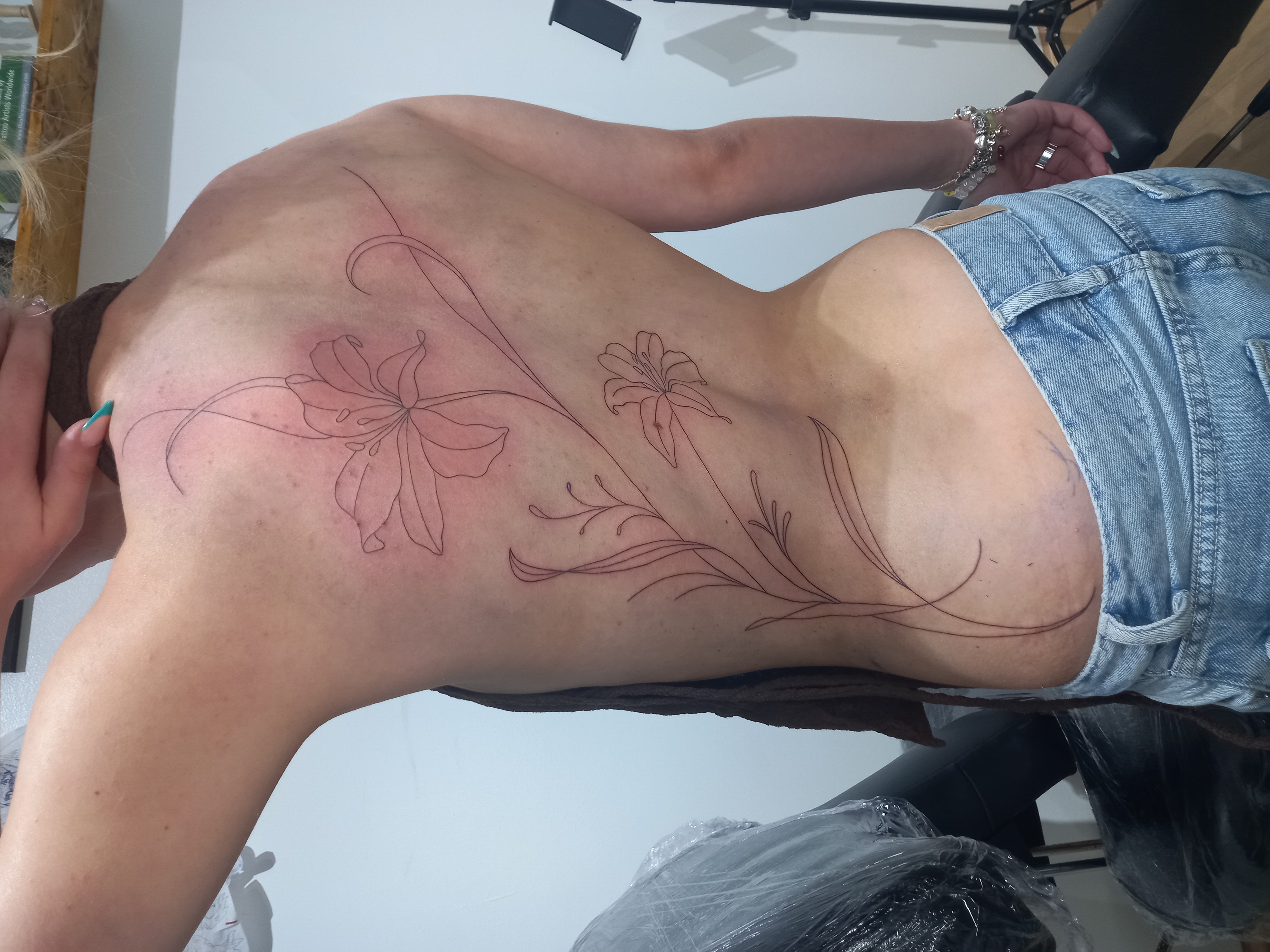 Lily flowers fine line back piece tattoo by Tori Talio
