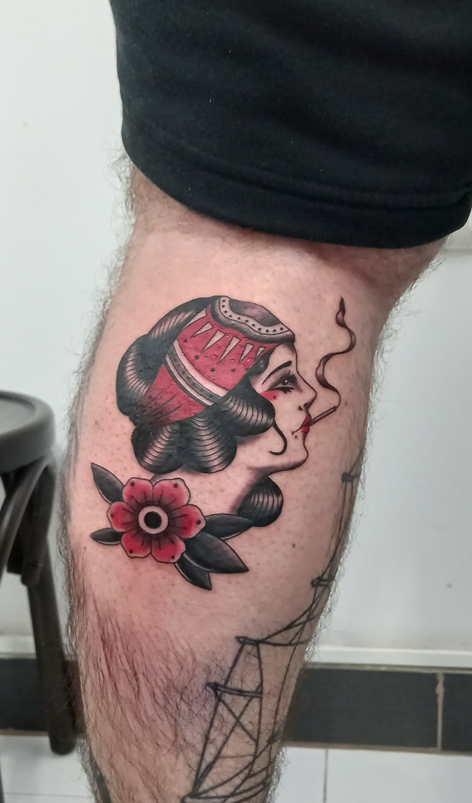 Traditional lady head smoking with flower calf tattoo by Tori Talio