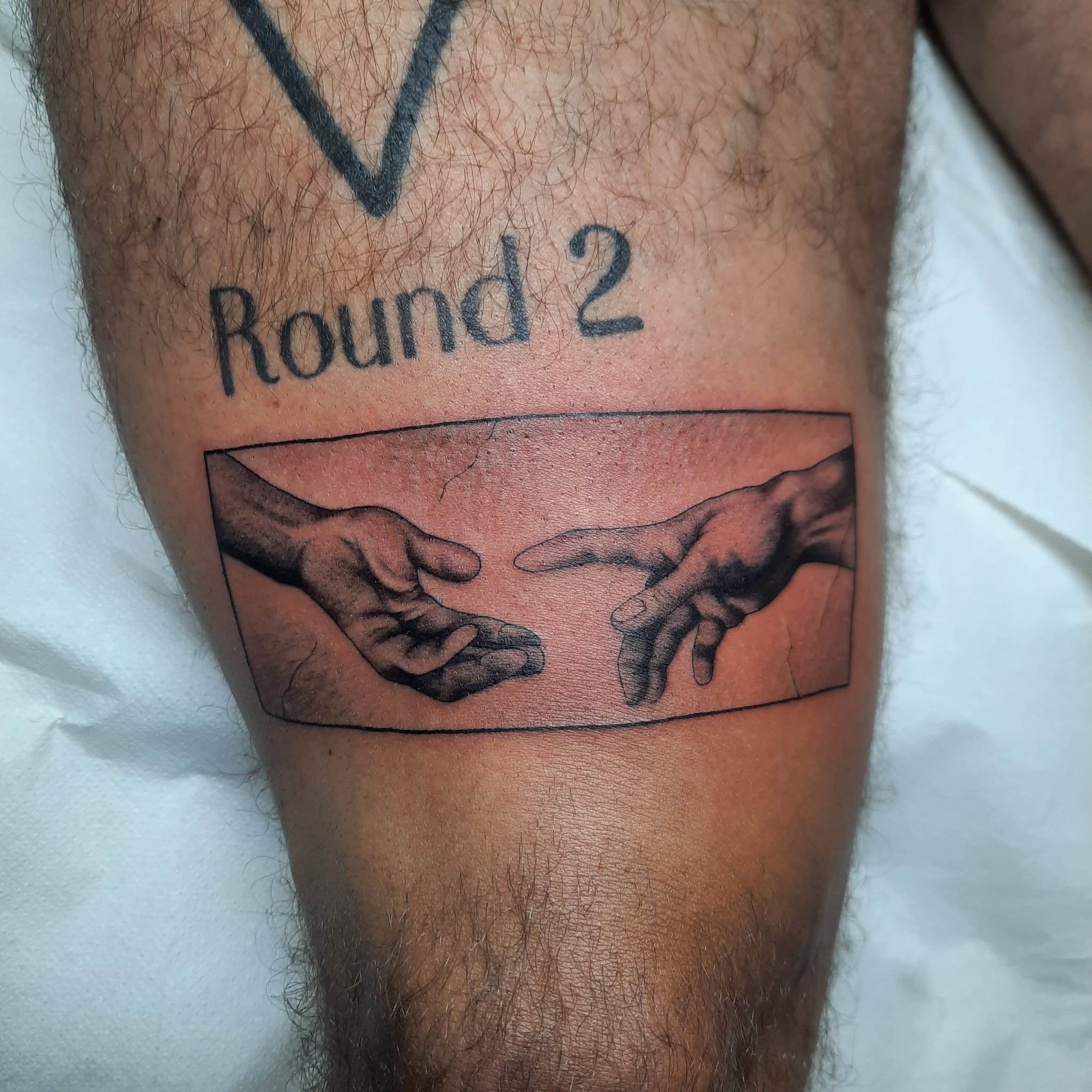 Creation of Adam hands Round 2 leg tattoo by Luca Falzon