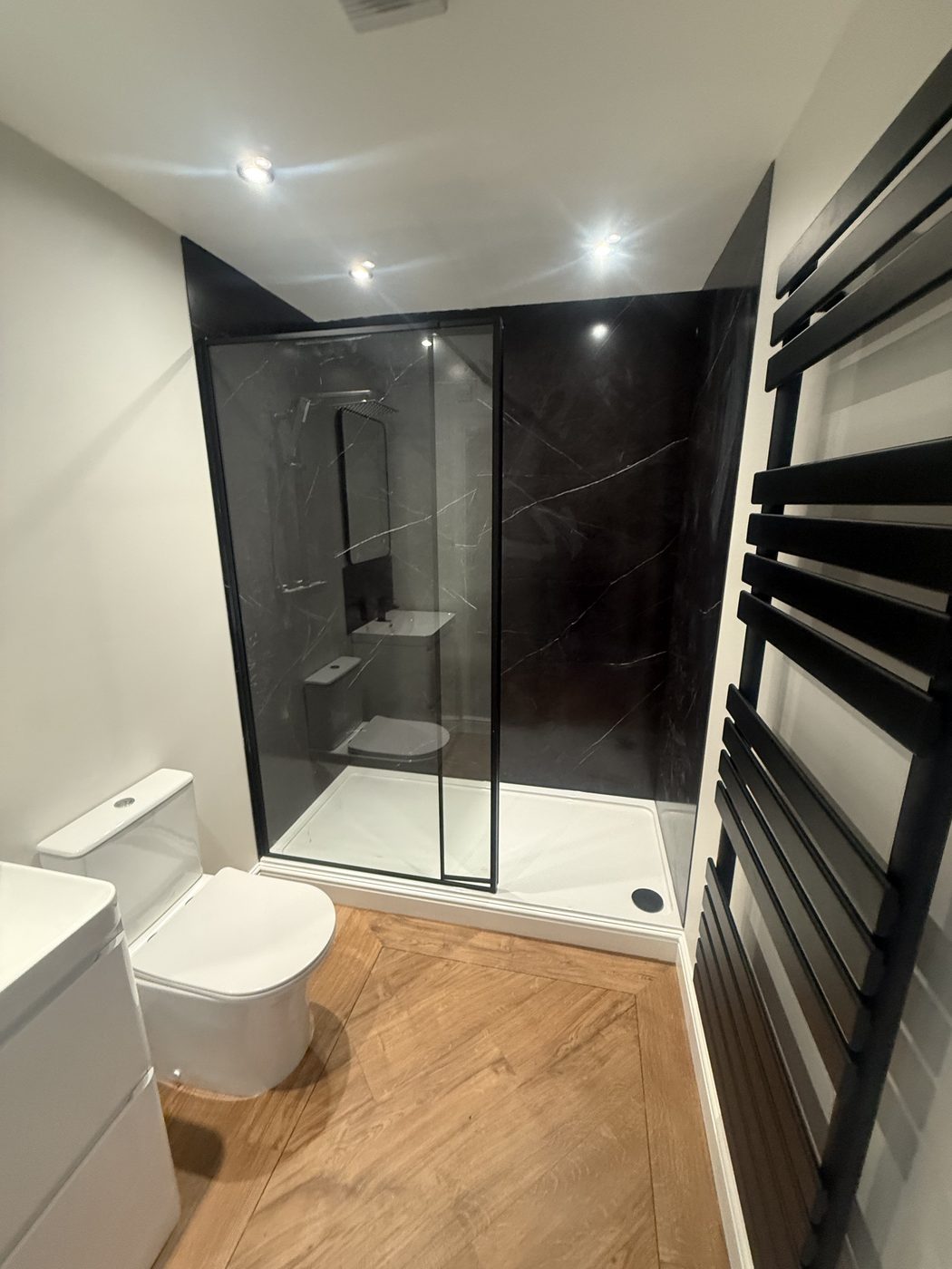Completed — dark marble shower, herringbone floor