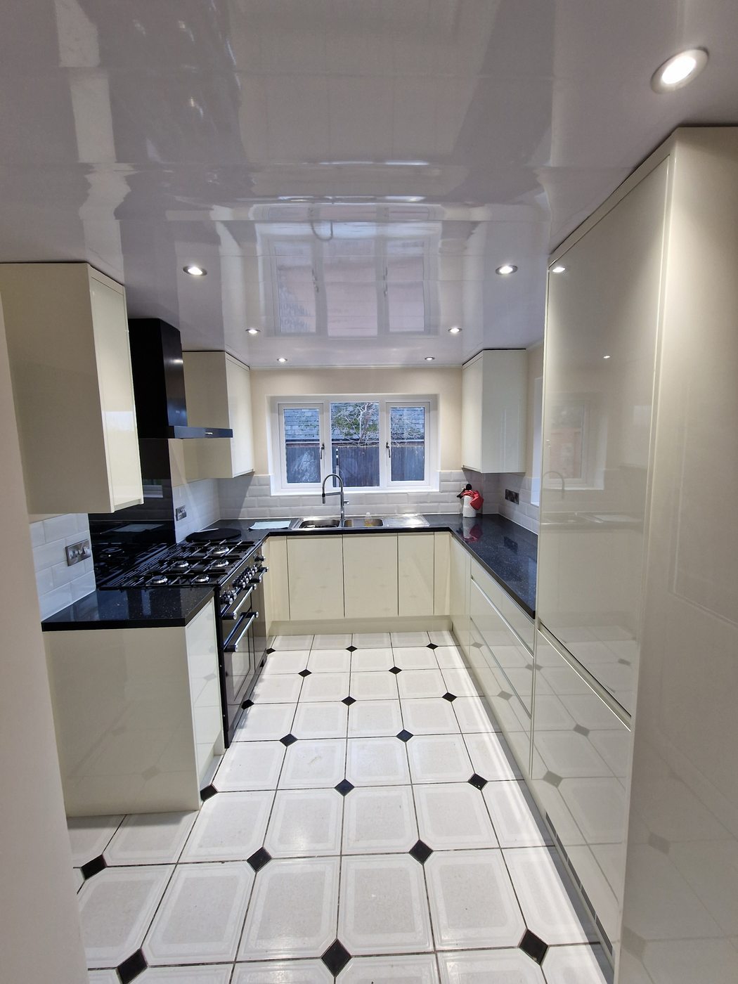 Full kitchen view — gloss units & range cooker