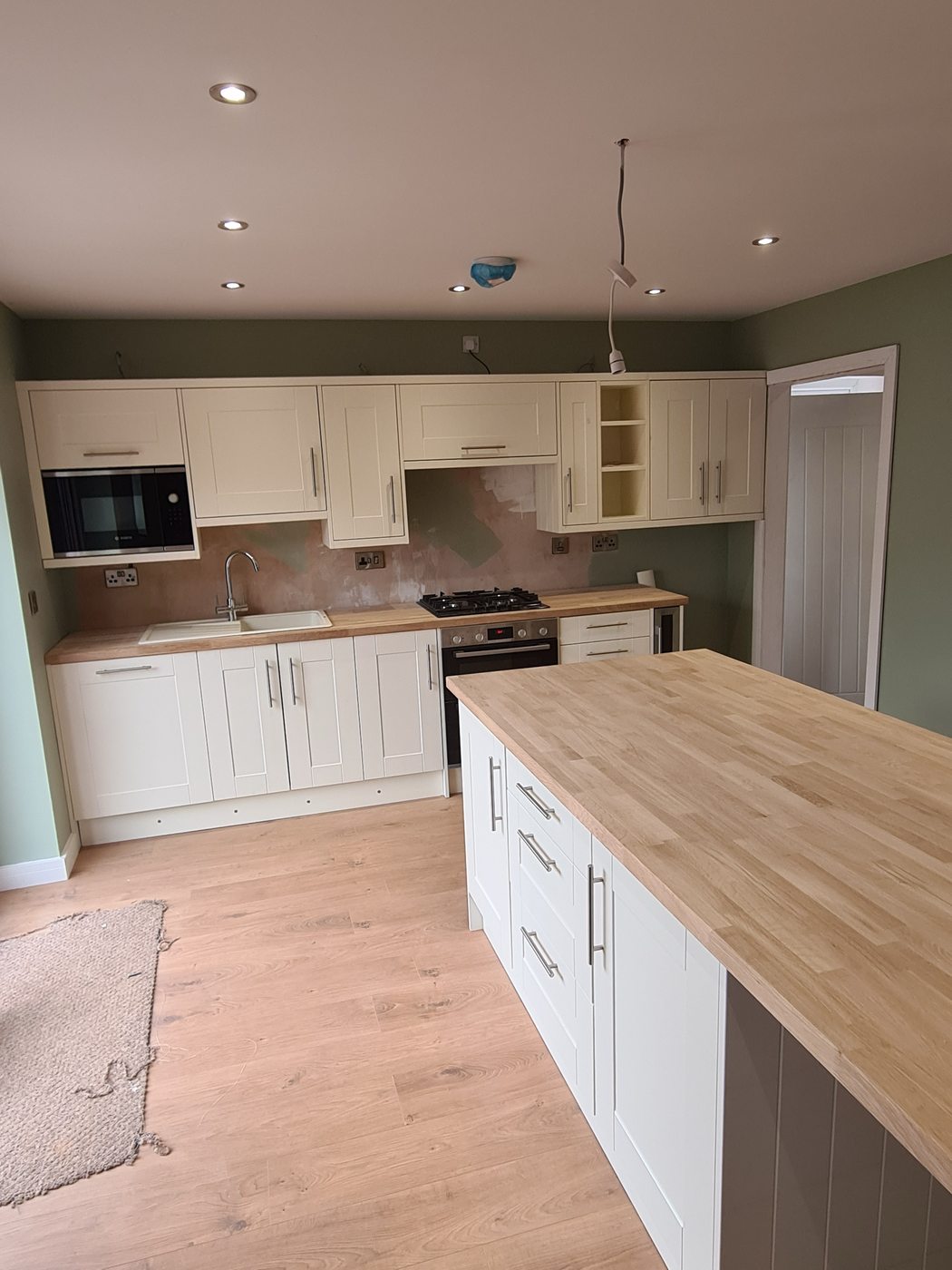 Completed kitchen installation Stoke-on-Trent — cream shaker units with oak island