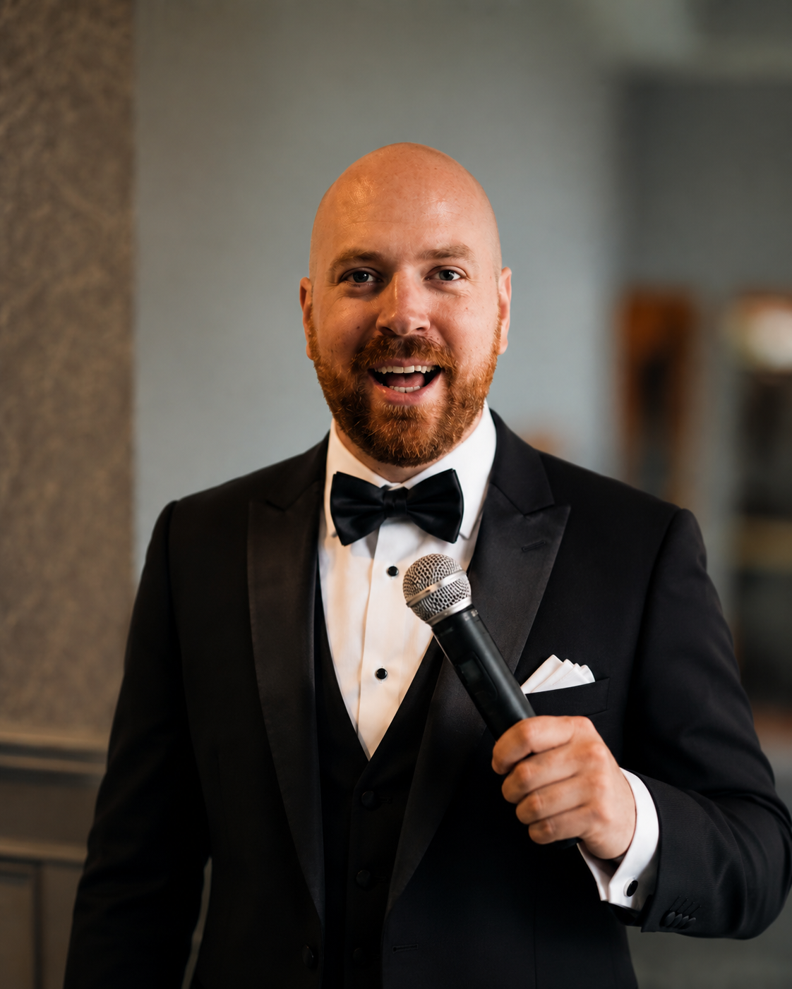 Ryan Wallace — The Opera Guy performing in a tuxedo with microphone at an elegant event