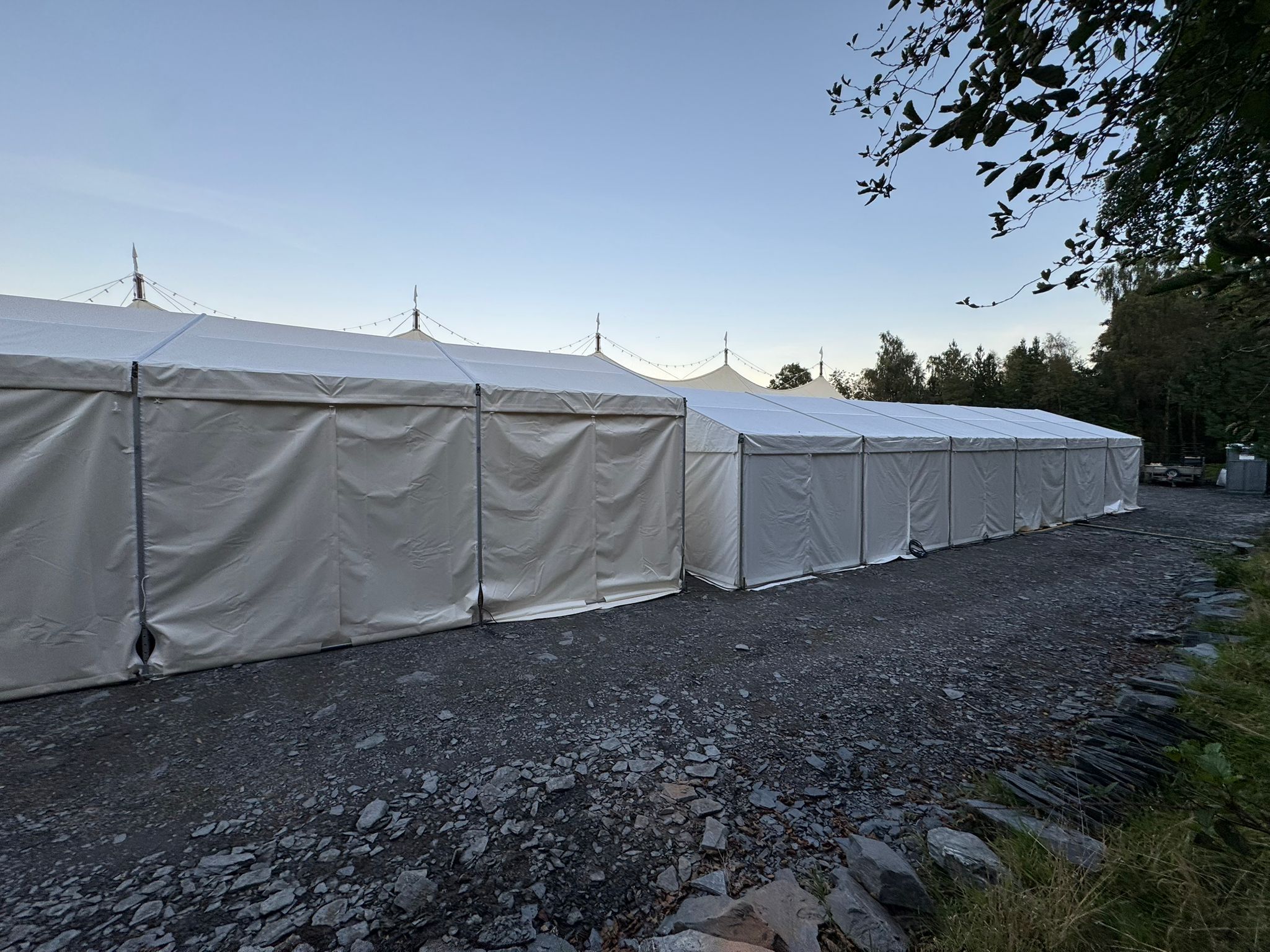 Catering tent exterior with sailcloth marquee peaks visible behind