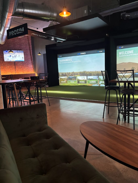 Salon lounge avec sofas confortables et simulateurs de golf - espace détente et événements privés au Golf Lounge Sherbrooke