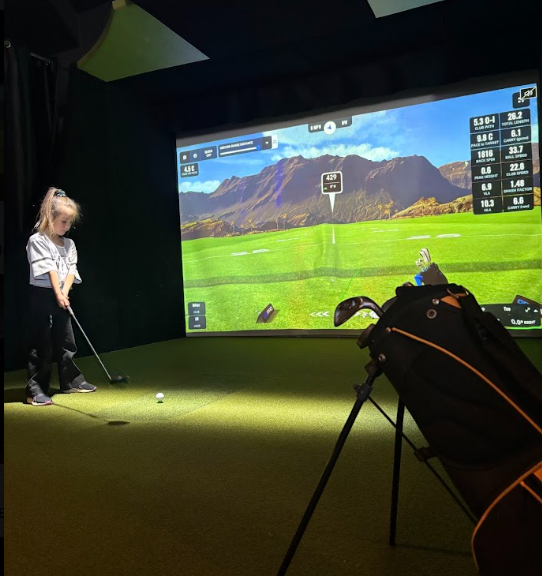 Enfant jouant au simulateur de golf GSPro - activité familiale et intérieure pour tous les âges au Golf Lounge Sherbrooke