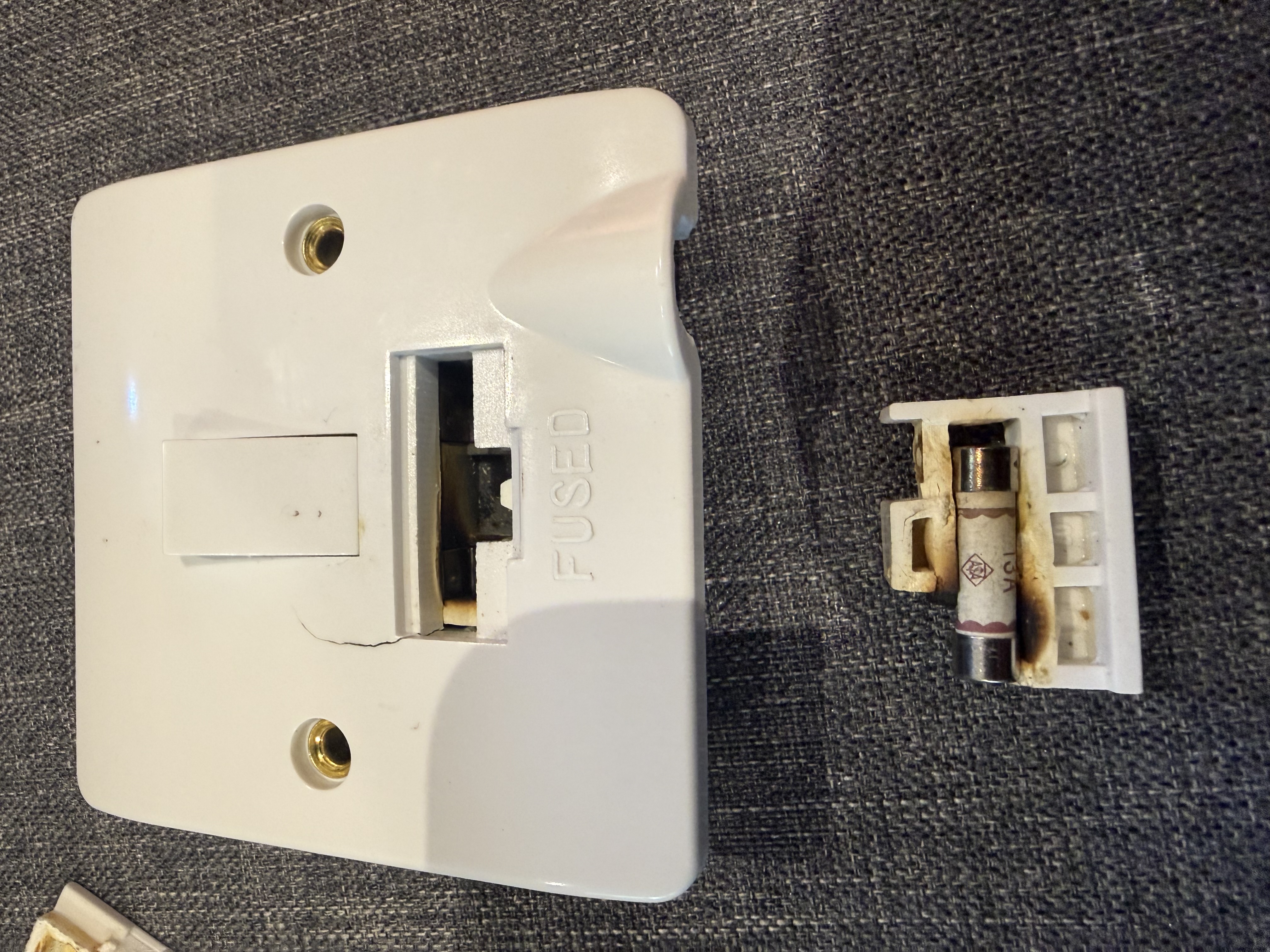 Back of the fused connection unit showing heat staining and brown discolouration on the rear plastic housing