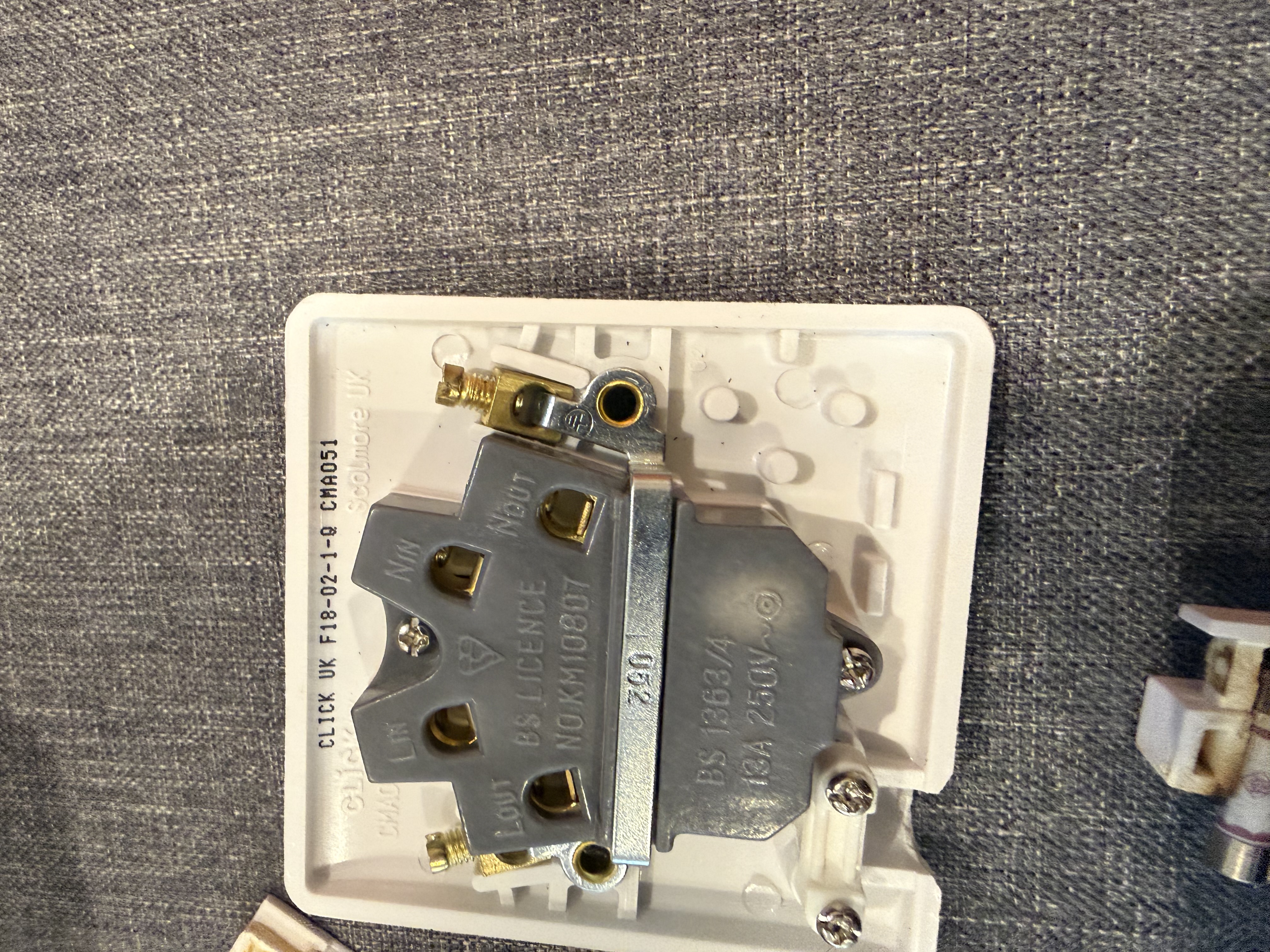 Fused connection unit with fuse carrier removed, showing severe heat damage, charring and browning on the carrier and housing