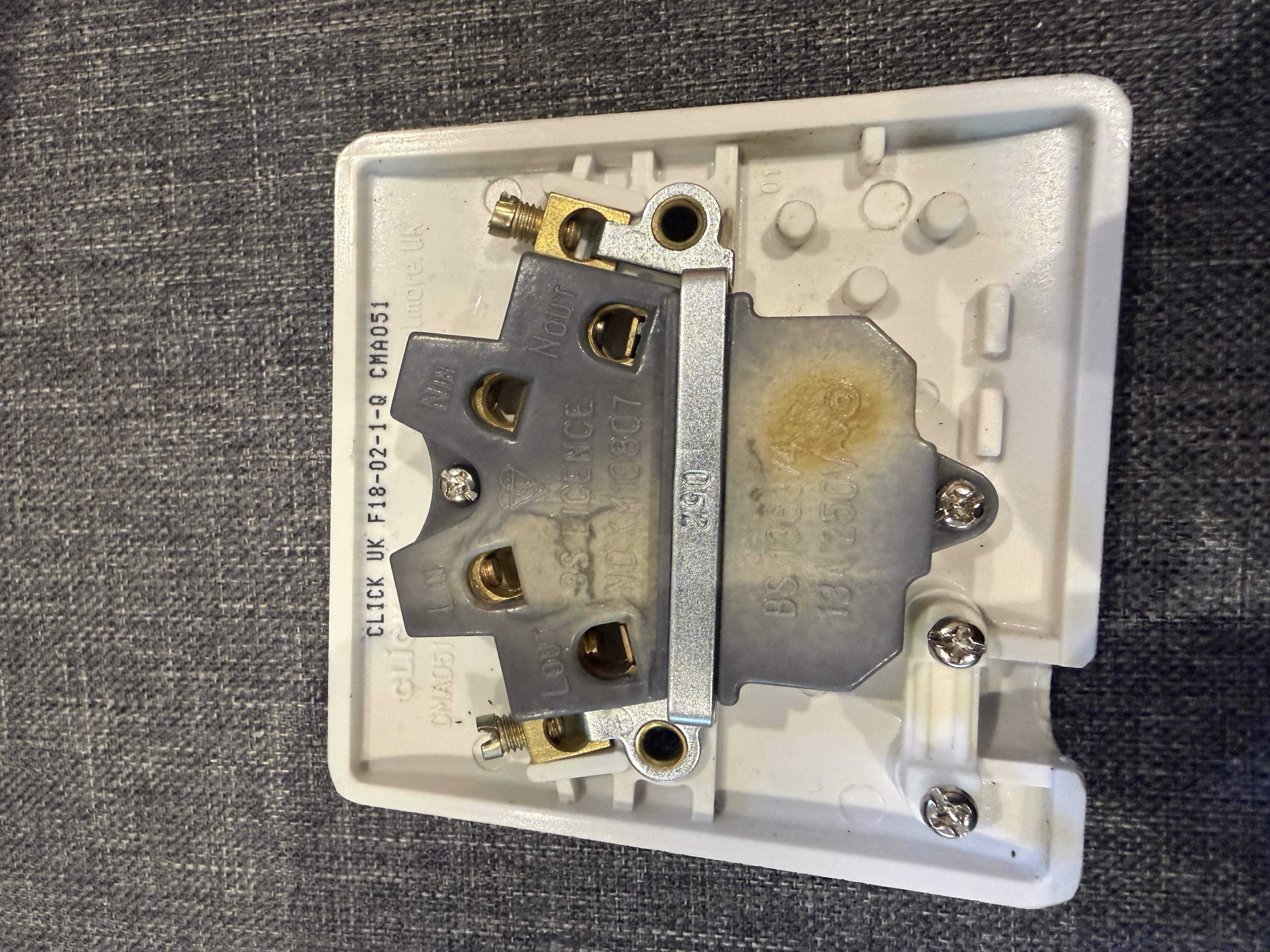 Fused connection unit showing cracked faceplate, charring and heat damage around the fuse carrier housing