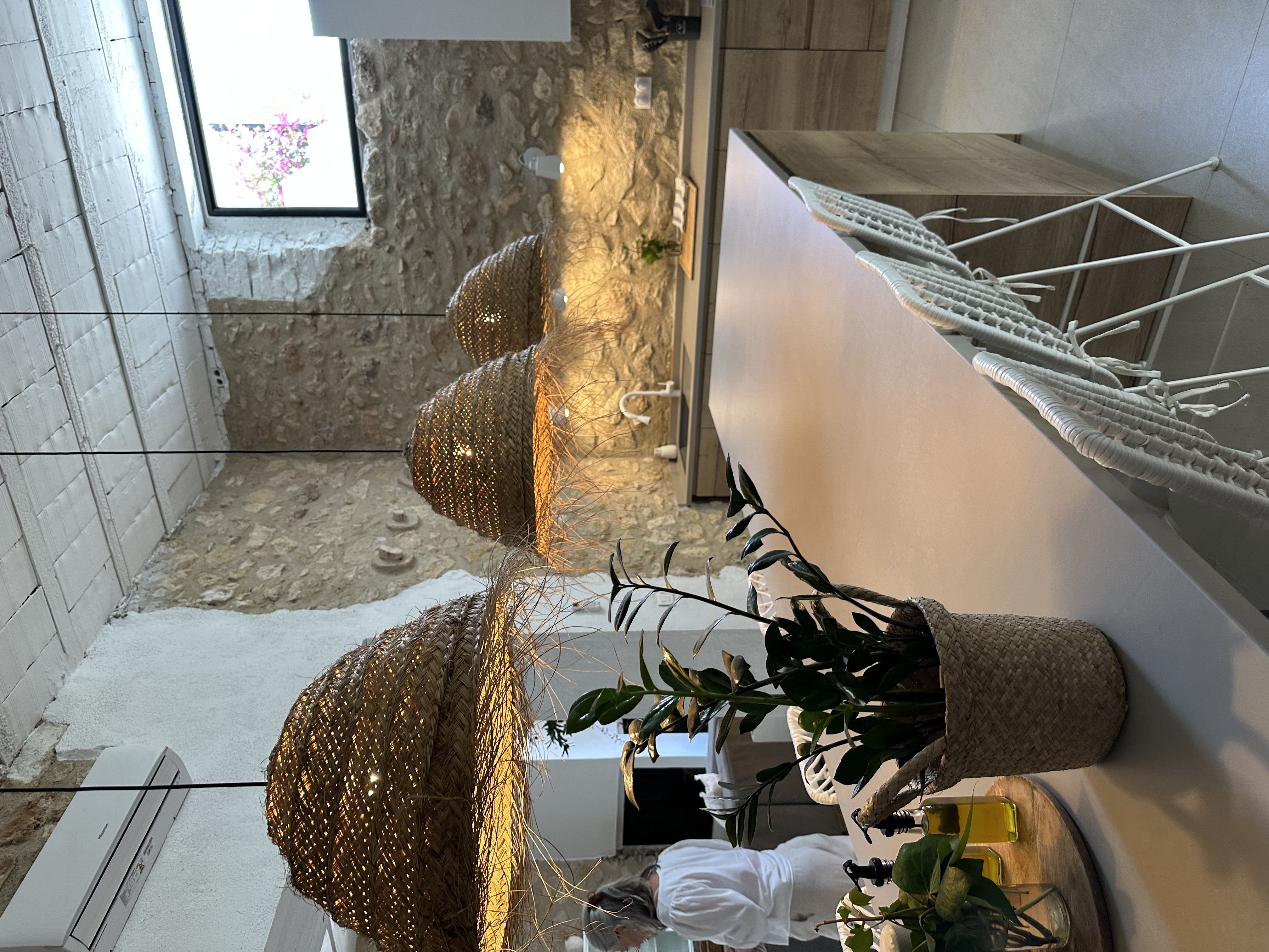 Kitchen with stone walls and woven pendant lights