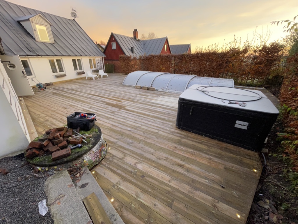 Stort trädäck med poolövertäckning och infälld belysning