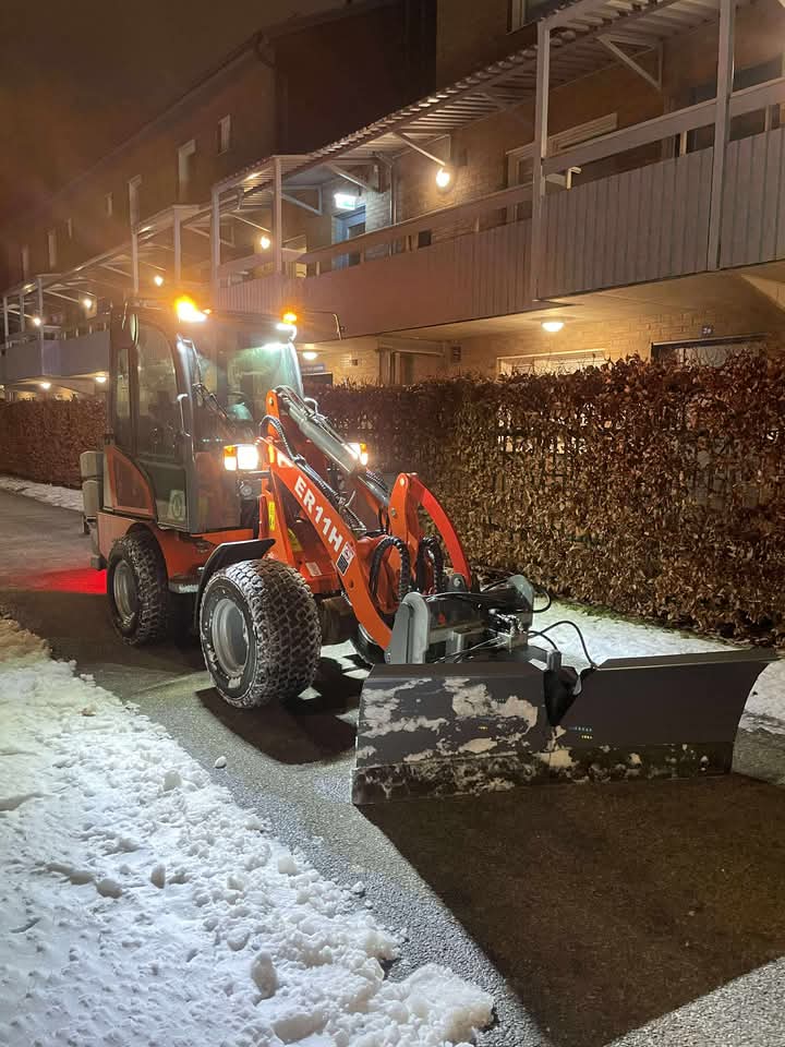Hjullastare med snöblad vid bostadsområde