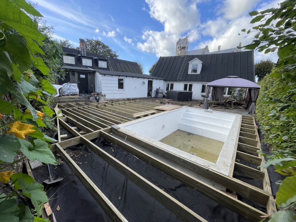 Altanbygge med poolinstallation och regelstomme under konstruktion