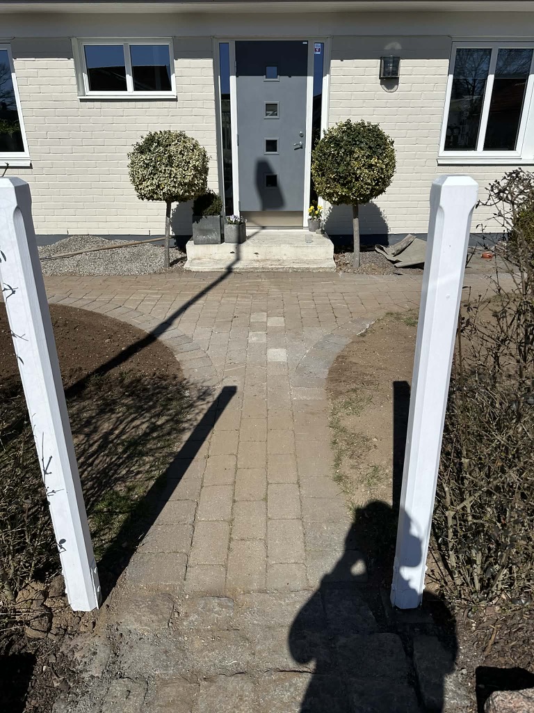Plattlagd gångväg med marksten fram till entré