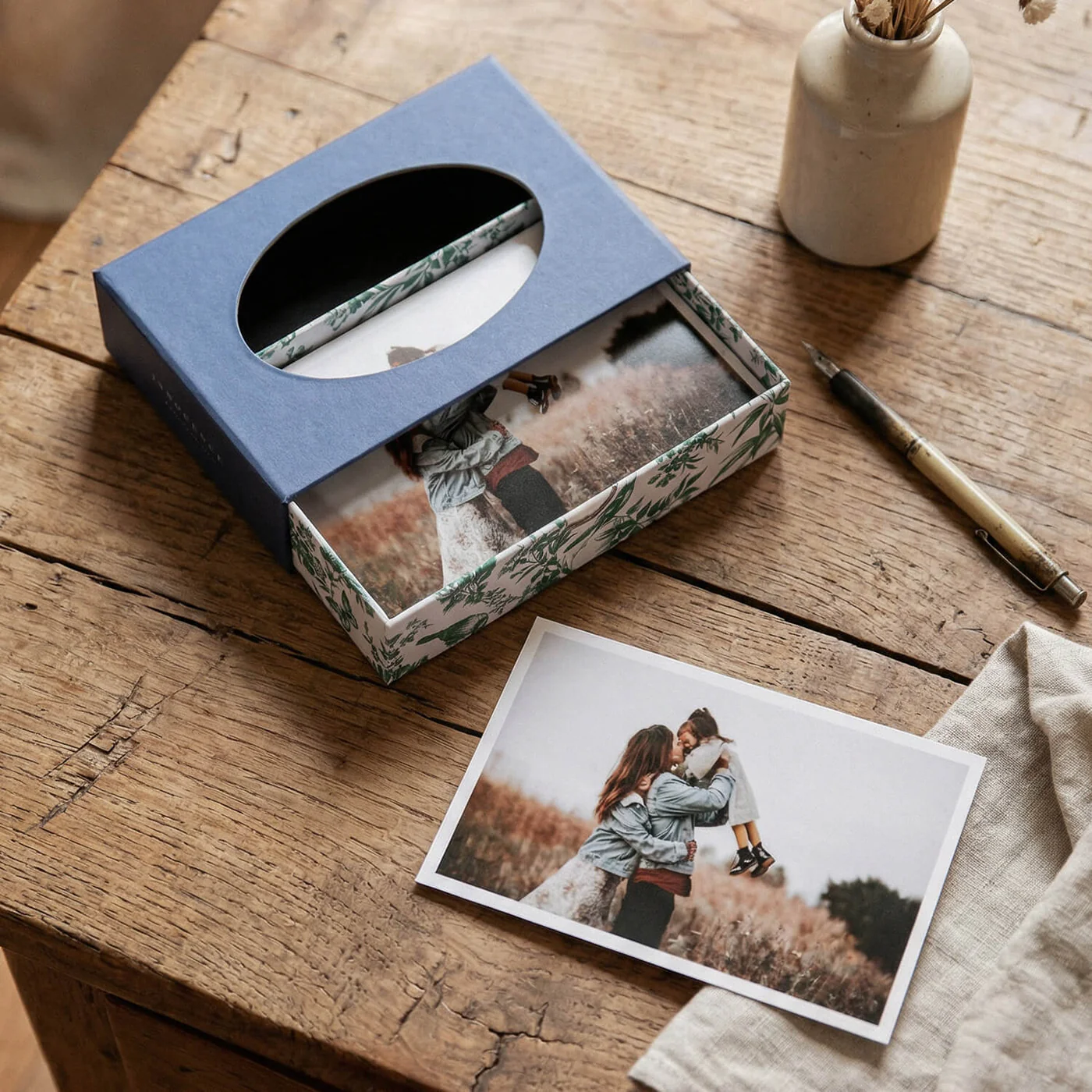 Classic Prints Box azul aberta em mesa de madeira — impressão de família