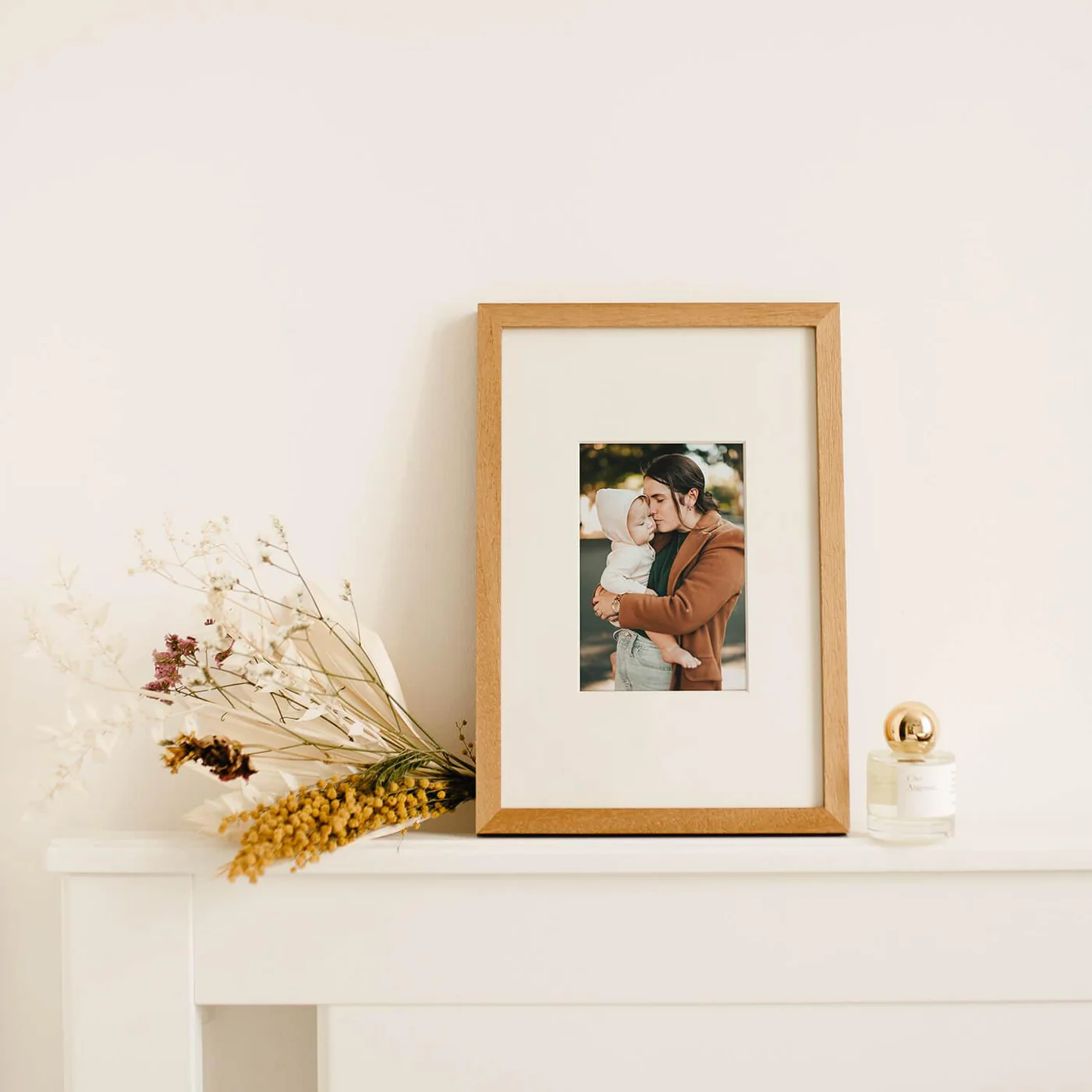 Wooden Framed Photo — moldura em cima de lareira com flores secas, mãe e bebé