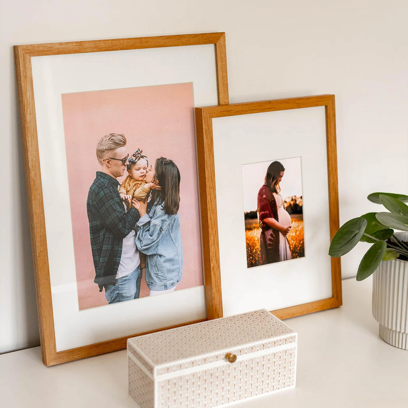 Wooden Framed Photo — duas molduras apoiadas na parede, família
