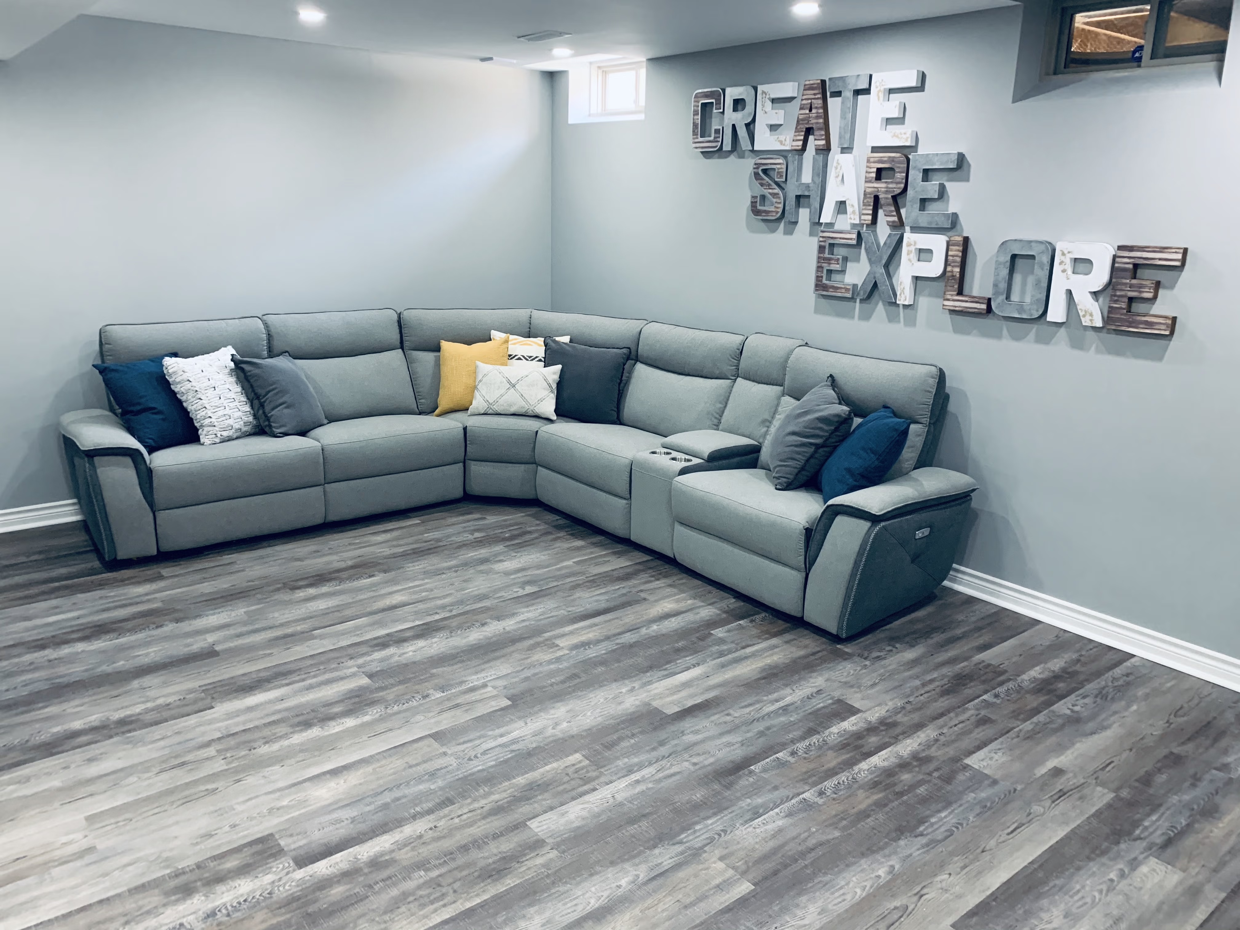 Basement playroom in Whitchurch-Stouffville, Ontario with LVT flooring and sectional sofa