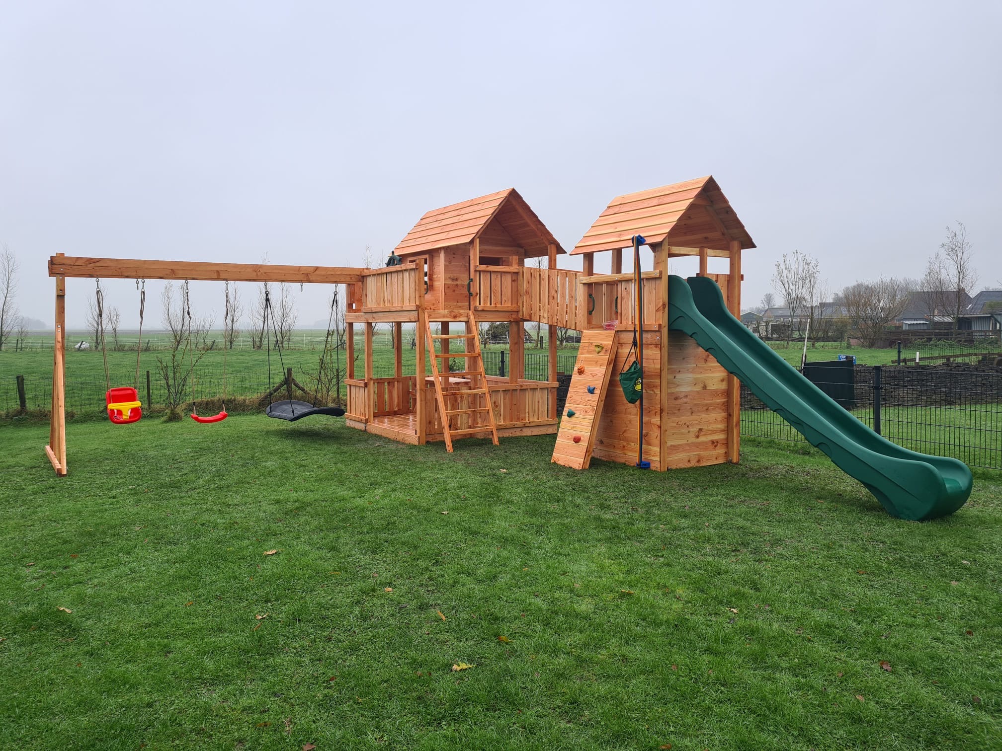 Groot houten speeltoestel met brug, twee torens en schommel - De Tuinaap