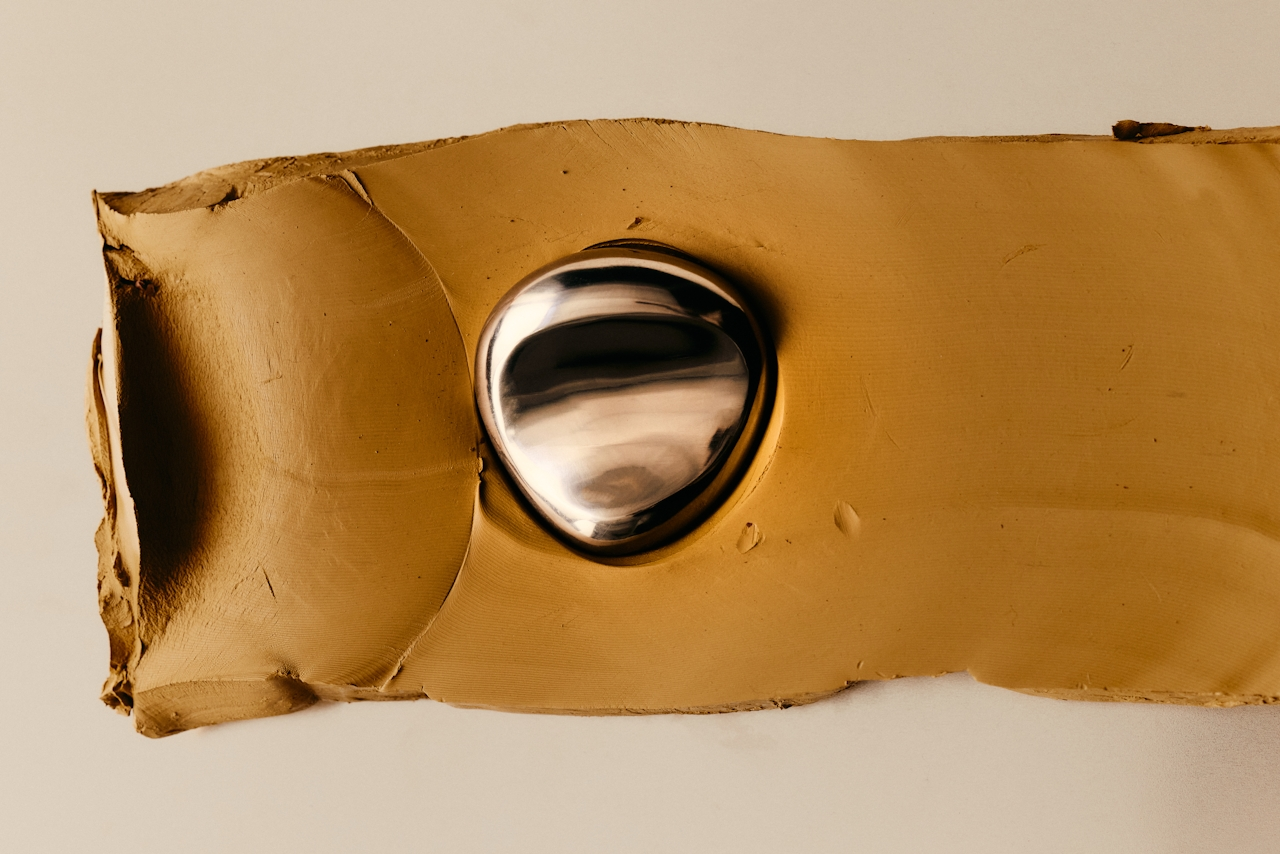 Clay sculpture with chrome sphere