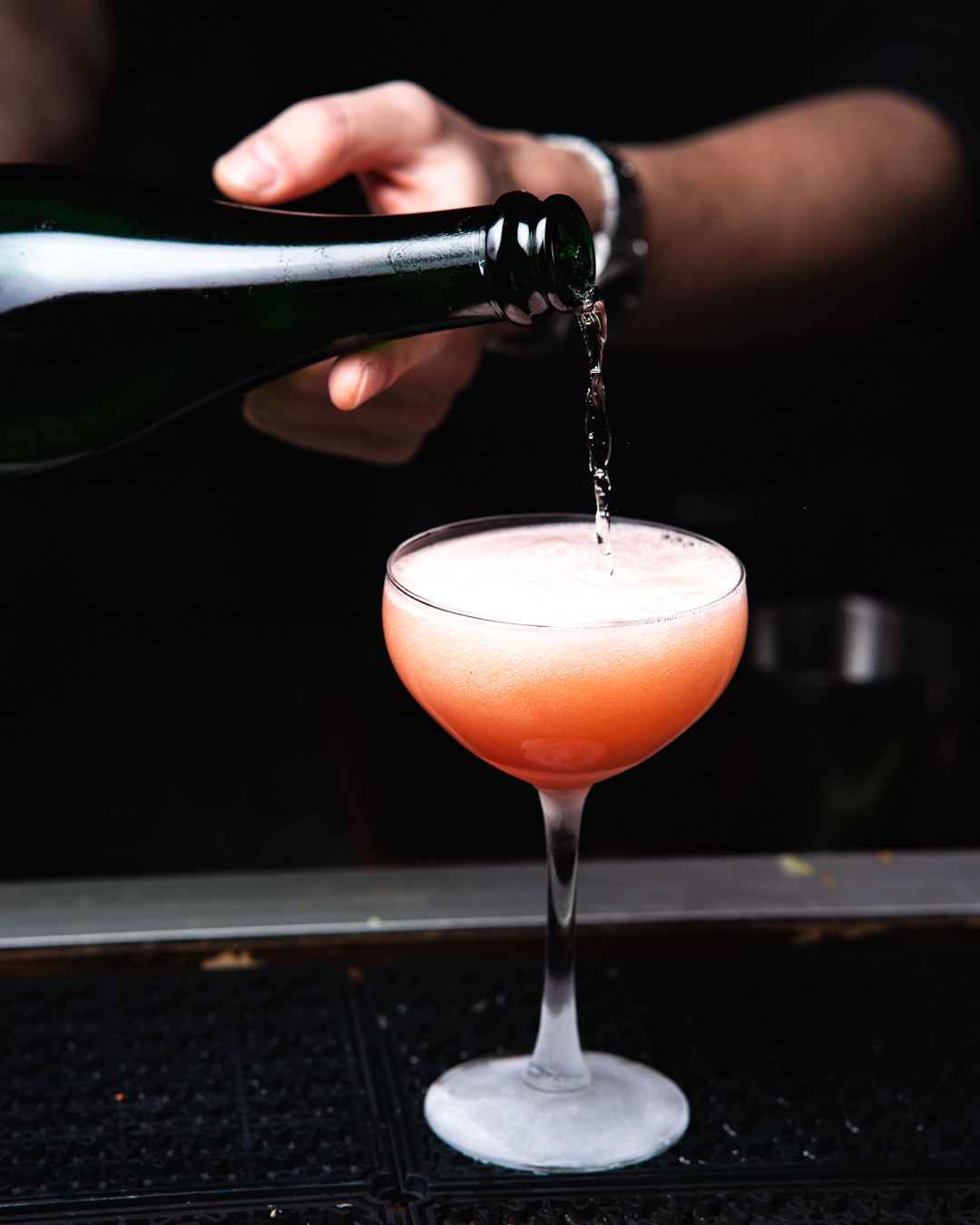 Cocktail im Coupe-Glas wird eingegossen