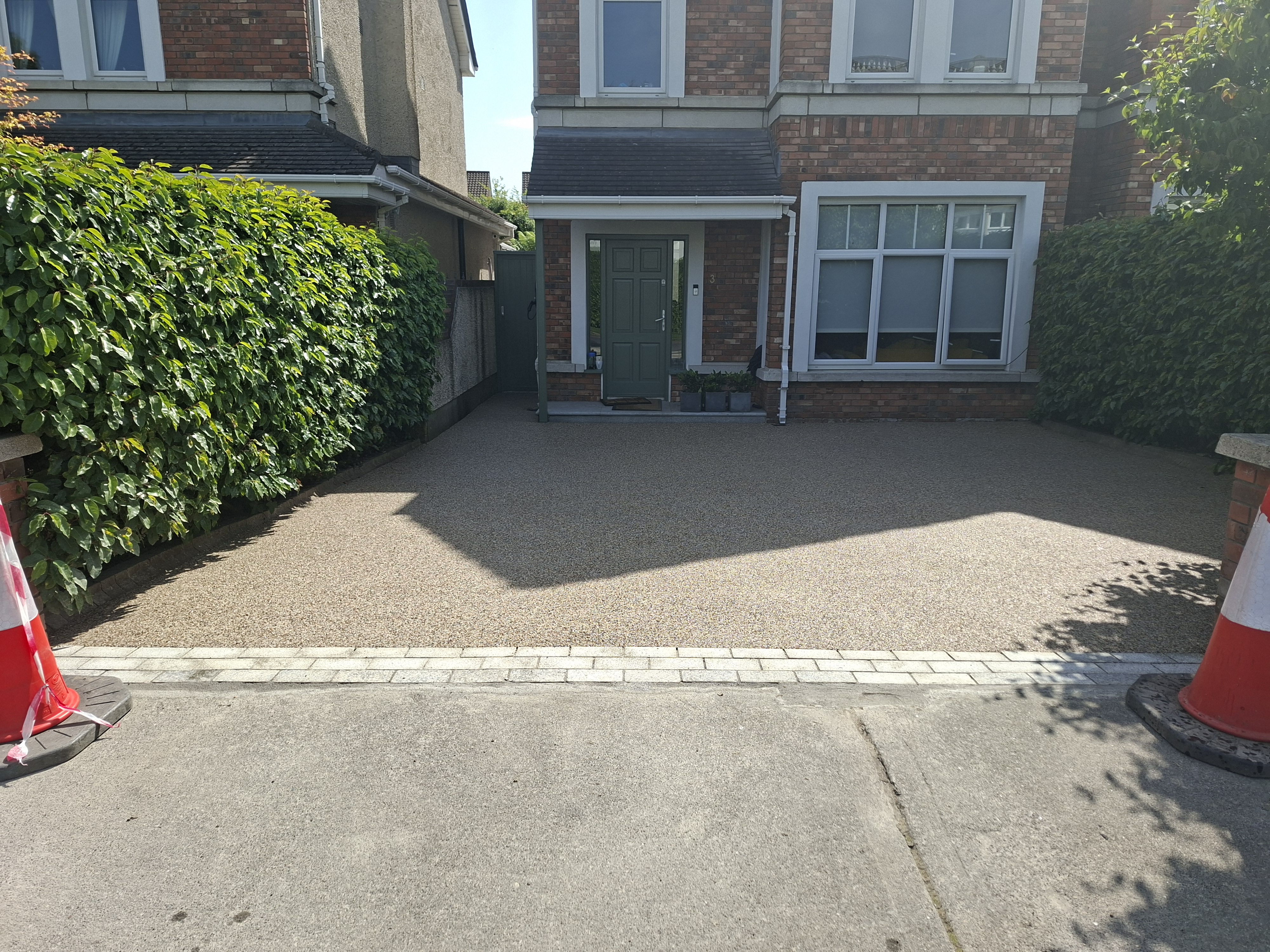 Resin bound driveway with warm stone aggregate outside a Dublin home, smooth seamless finish