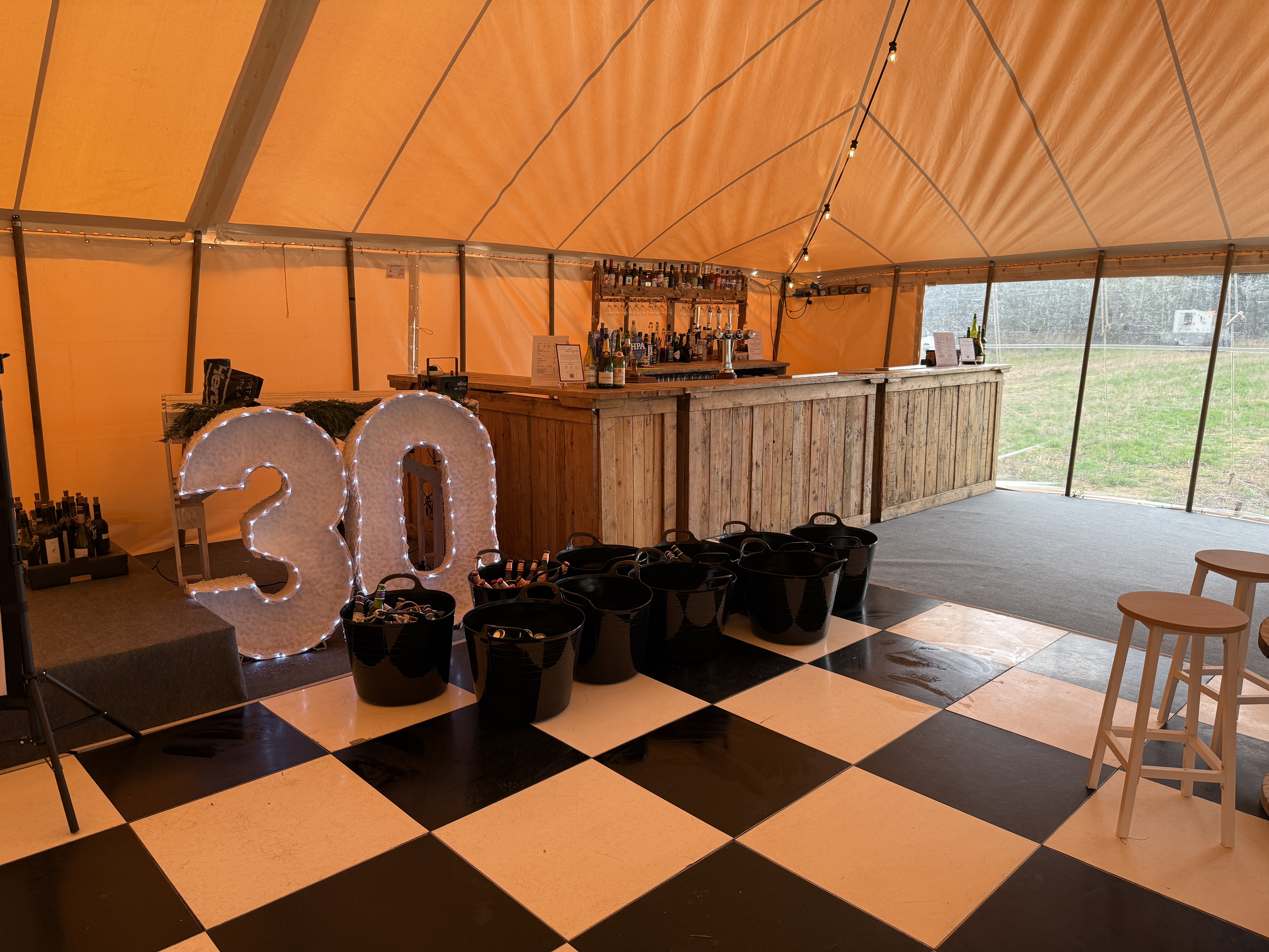 30th birthday party setup with bar in a tipi tent
