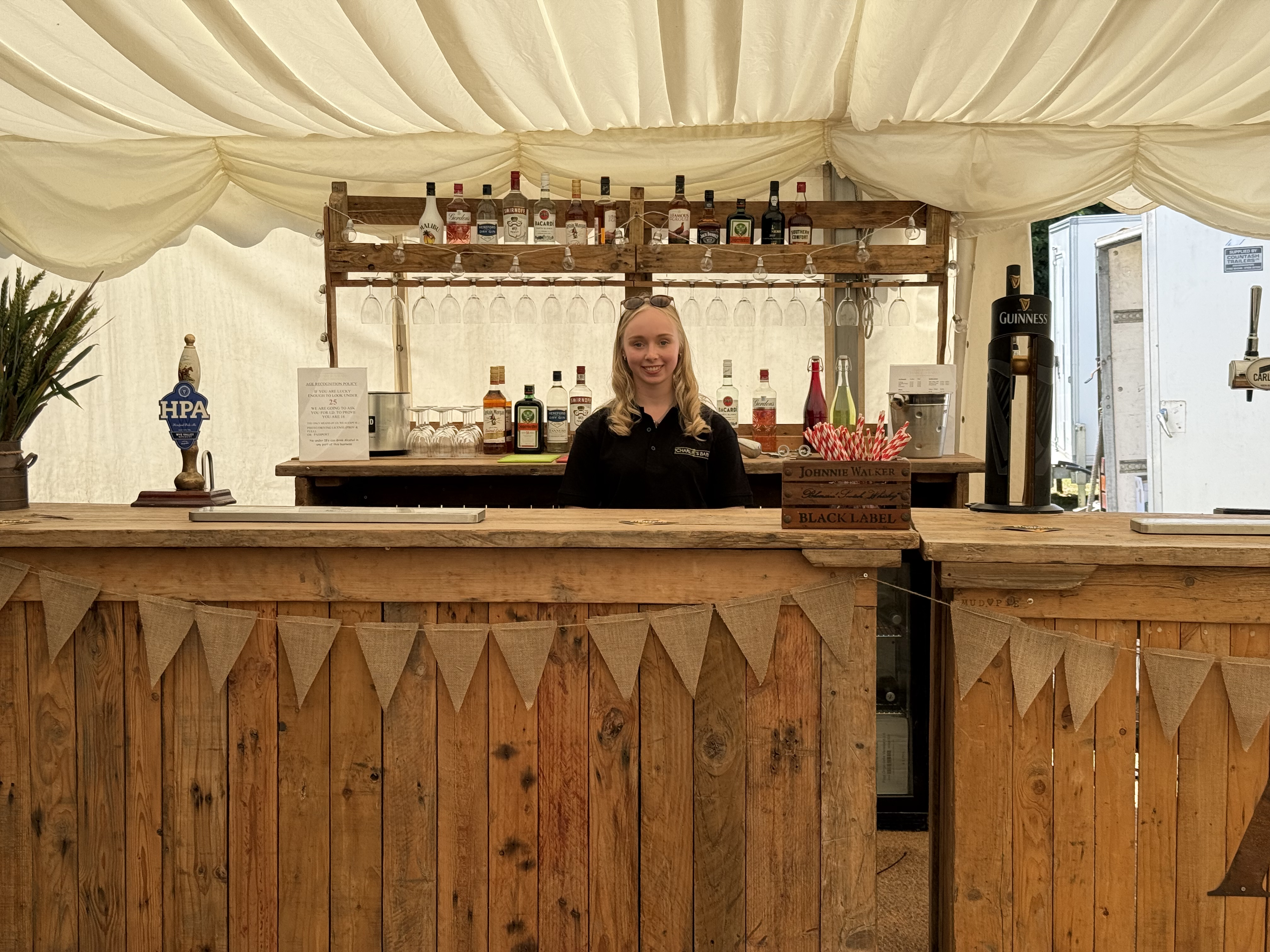 Friendly bartender behind the vintage wooden bar setup