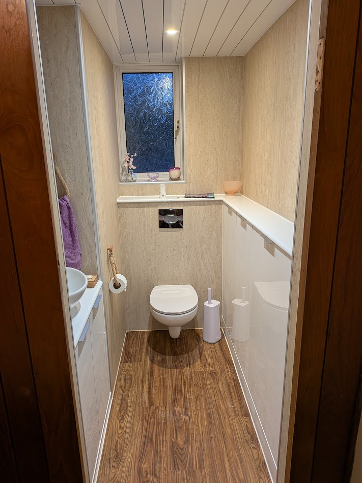 Completed WC with wall panels, LVT flooring and wall-hung toilet by Woodgate Joinery Glasgow
