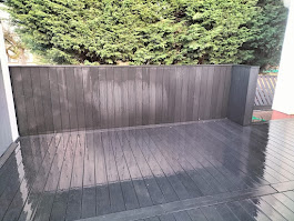 Dark grey composite decking with vertical timber fence panel by Woodgate Joinery Glasgow