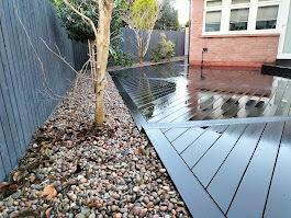 Dark composite decking pebble border by Woodgate Joinery Glasgow