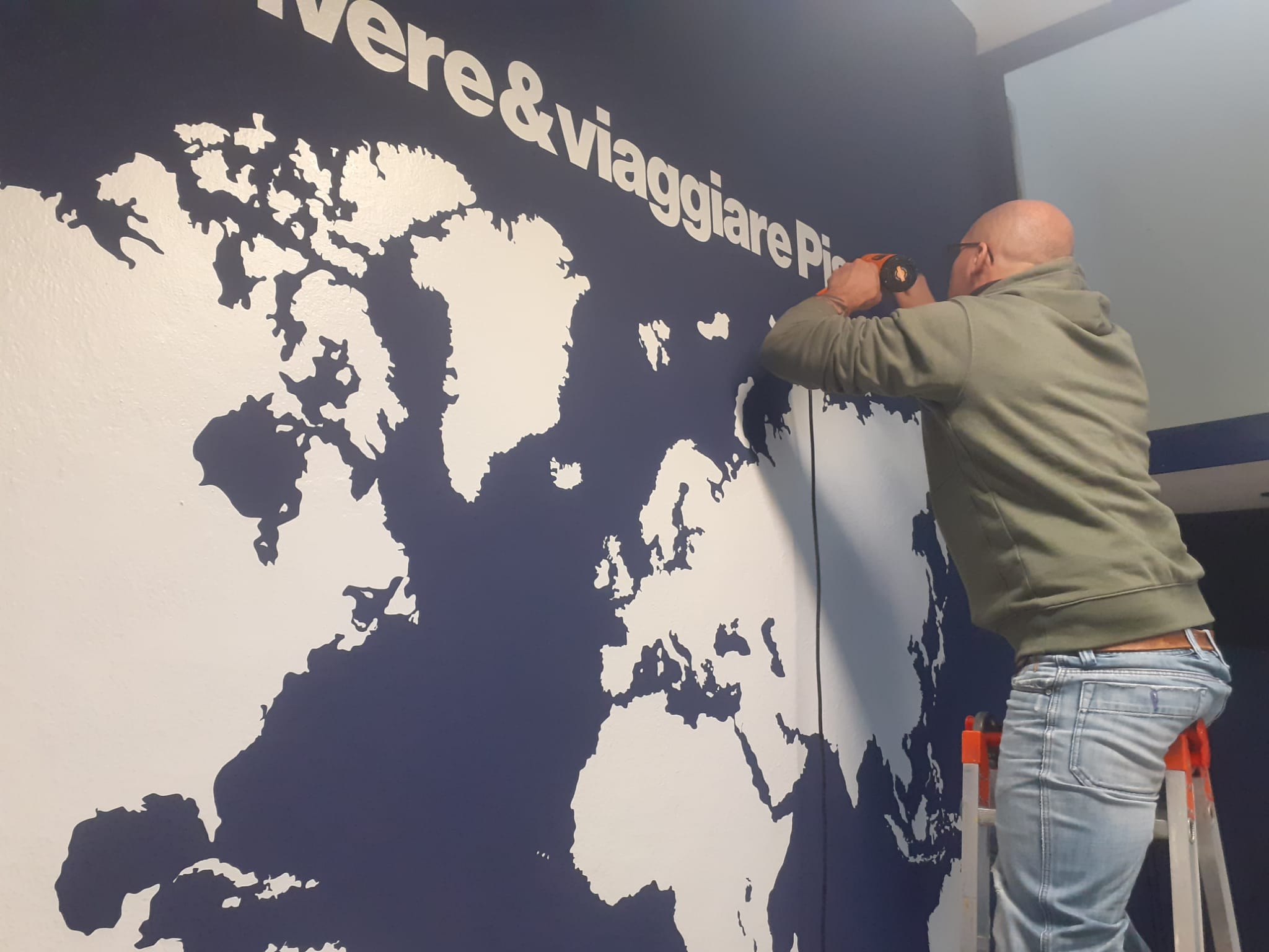 Decorazione su muro con adesivo pre-spaziato presso agenzia Vivere e Viaggiare, Pisa