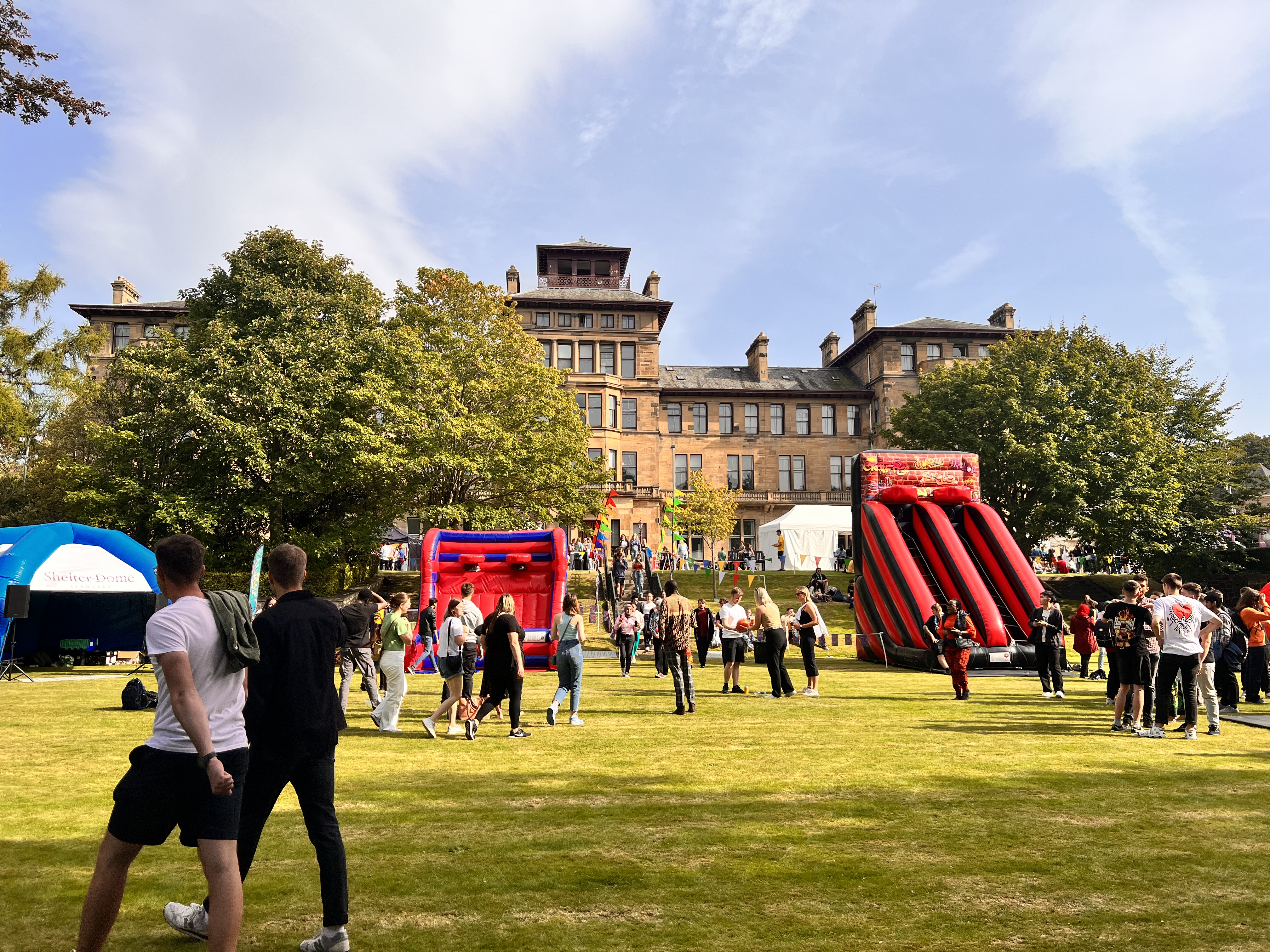 Event Collection corporate fun day with inflatables and outdoor activities in front of a grand Scottish venue, organised by Event Collection UK
