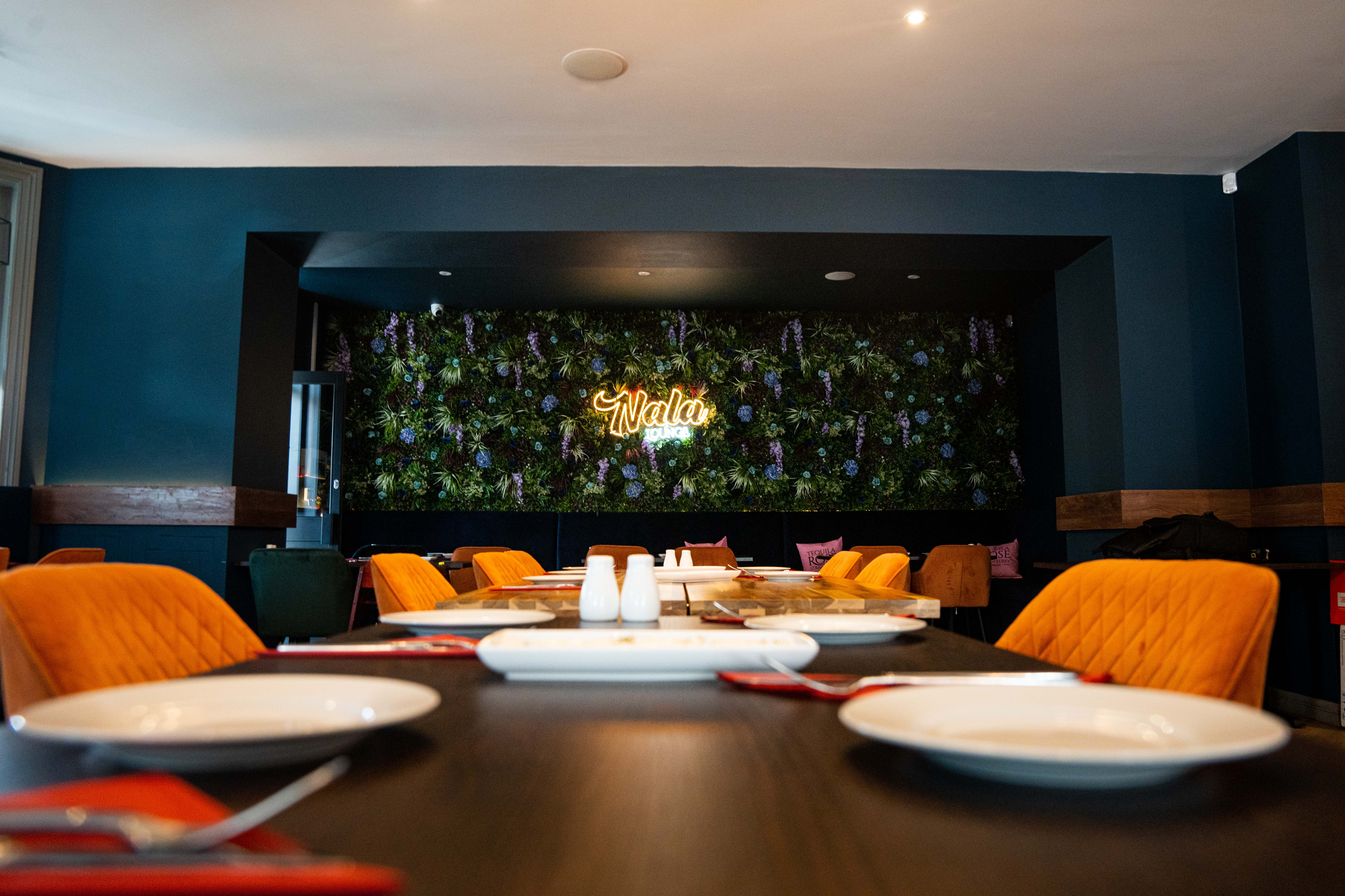 Nala Lounge interior — elegant table setting with flower wall and warm lighting