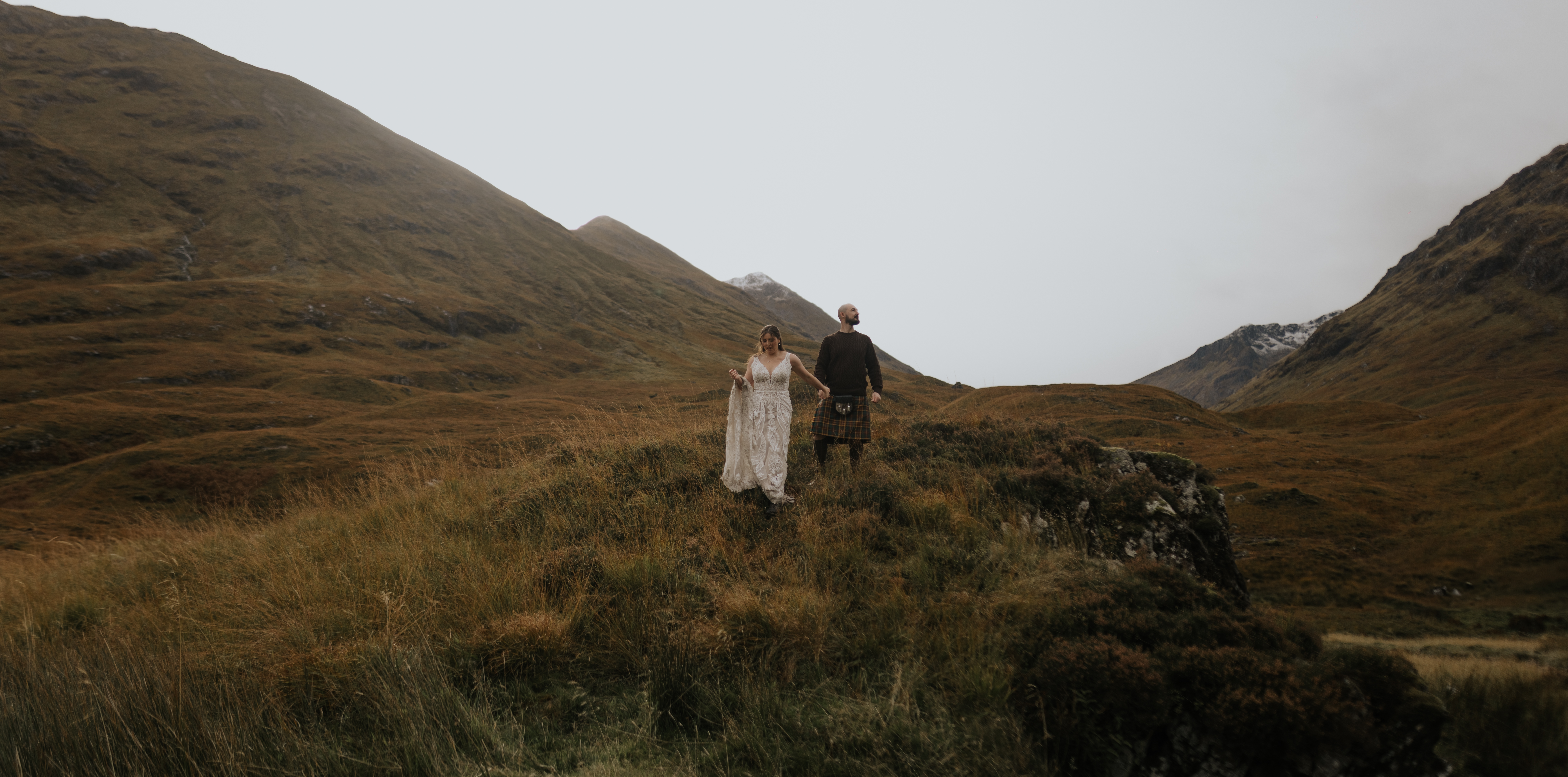 Wedding couple walking through a mountain landscape
