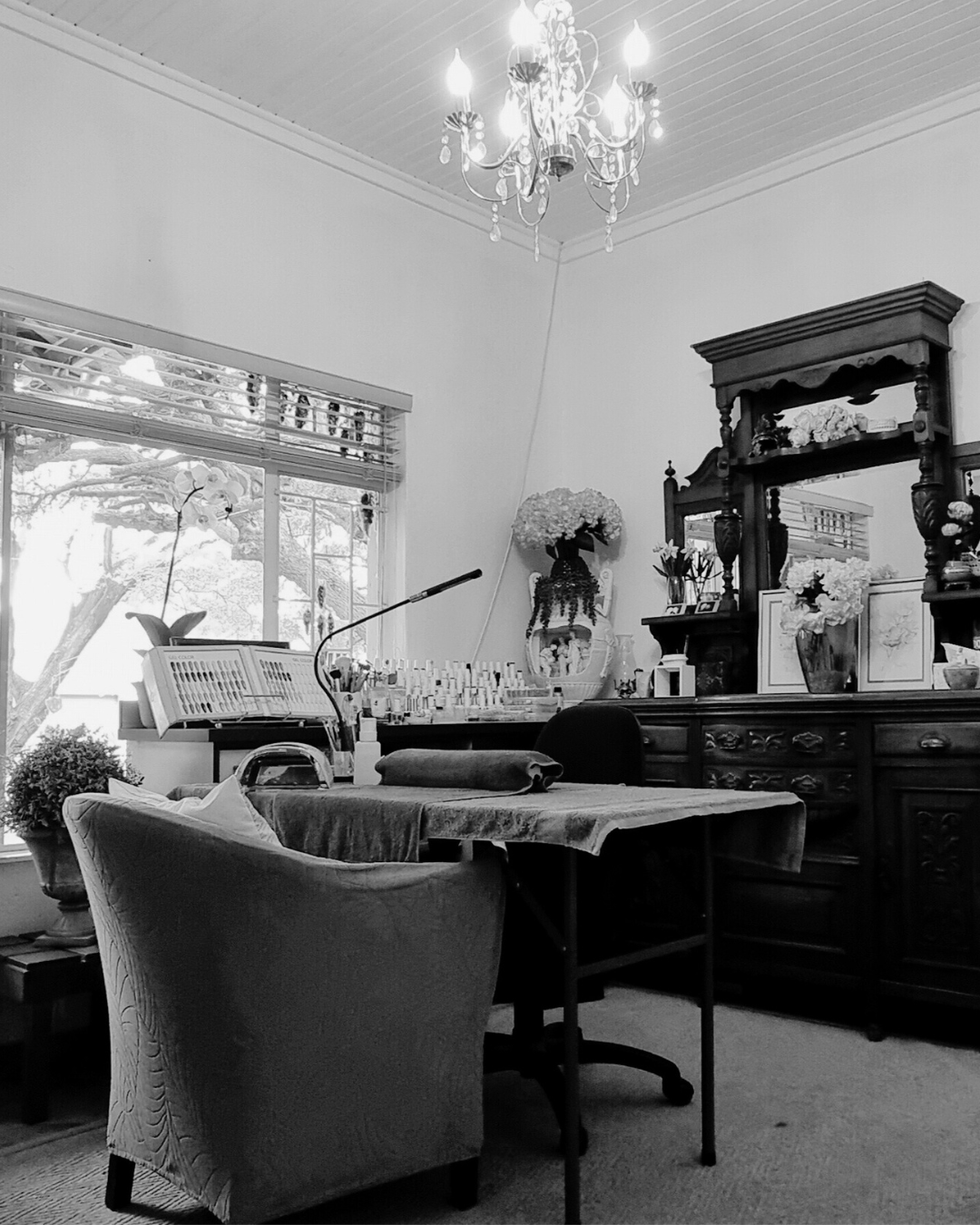 Bloom and Blissful Beauty Wellness salon interior with elegant chandelier and nail station by Emmie