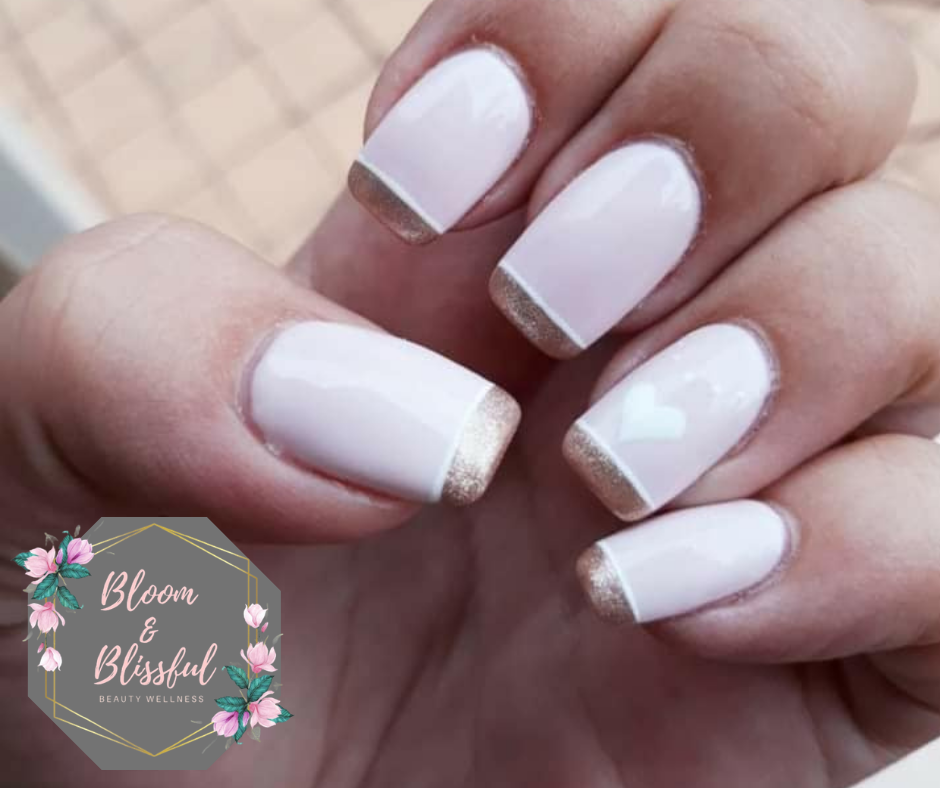 White French tip nails with gold glitter tips and heart accent by Emmie