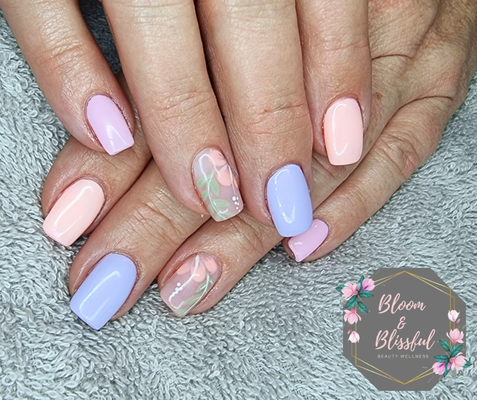 Pastel spring nails in lavender peach and periwinkle with floral accent art by Emmie