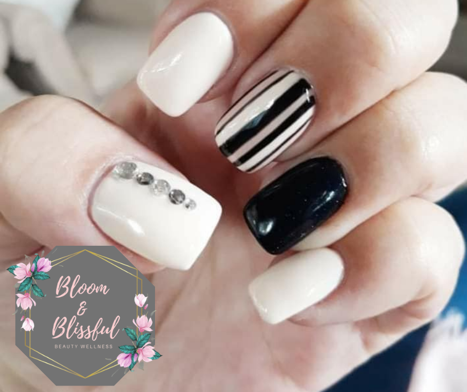 Black and white striped nails with rhinestone accent by Emmie