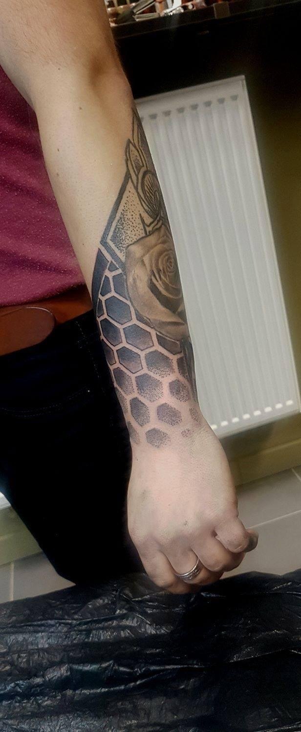 Onderarm met honingraat in dotwork-schaduw en een realistische roos